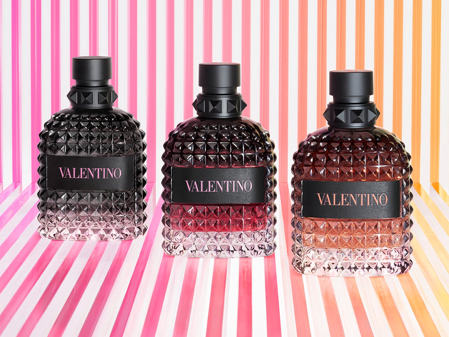 Découvrez les parfums Valentino, présentés dans des flacons à motifs cloutés, allant du noir profond au rouge et à l'ambre, pour une expérience olfactive unique.