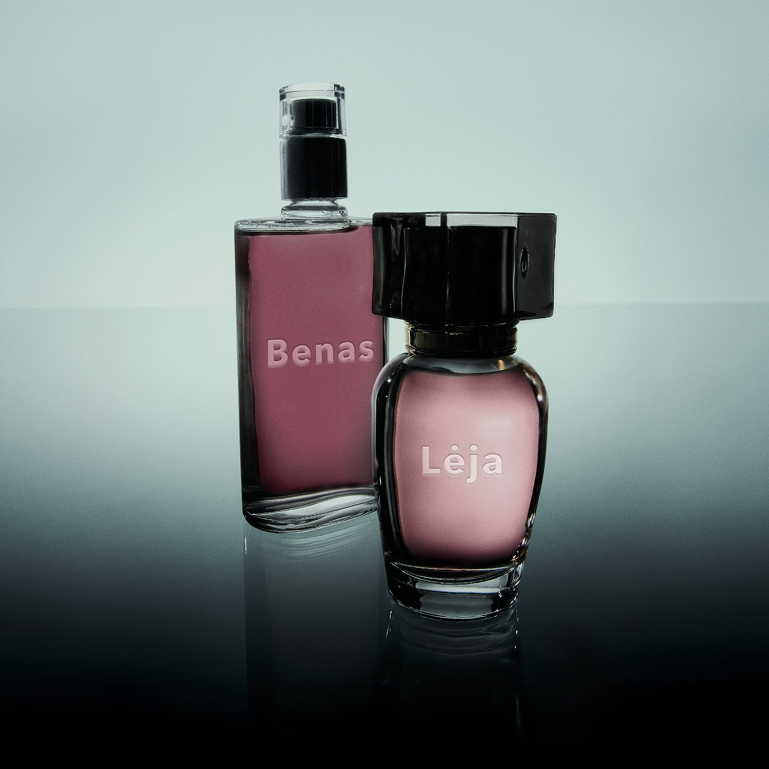 Du stikliniai kvepalų buteliukai su juodais kamšteliais, vienas su užrašu „Bena“, kitas – „Lėja“, pripildyti rausvu skysčiu.