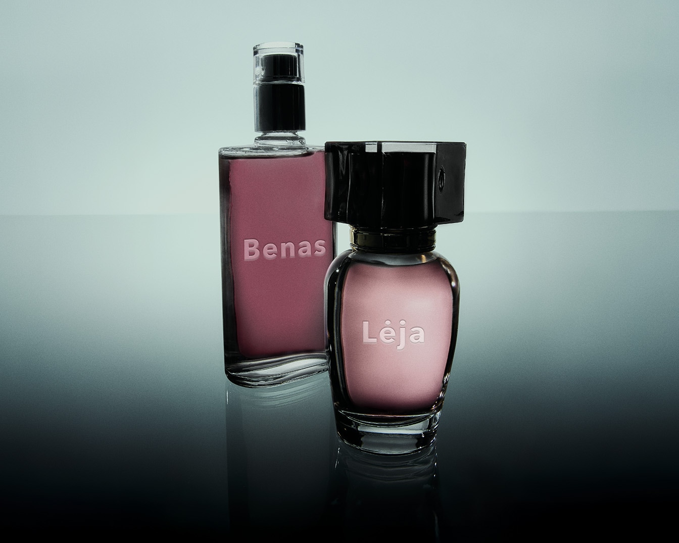 Du elegantiški kvepalų buteliukai: aukštas stačiakampis buteliukas su užrašu „Benas“ ir žemas apvalus buteliukas su užrašu „Lėja“, abu su rausvu skysčiu viduje.