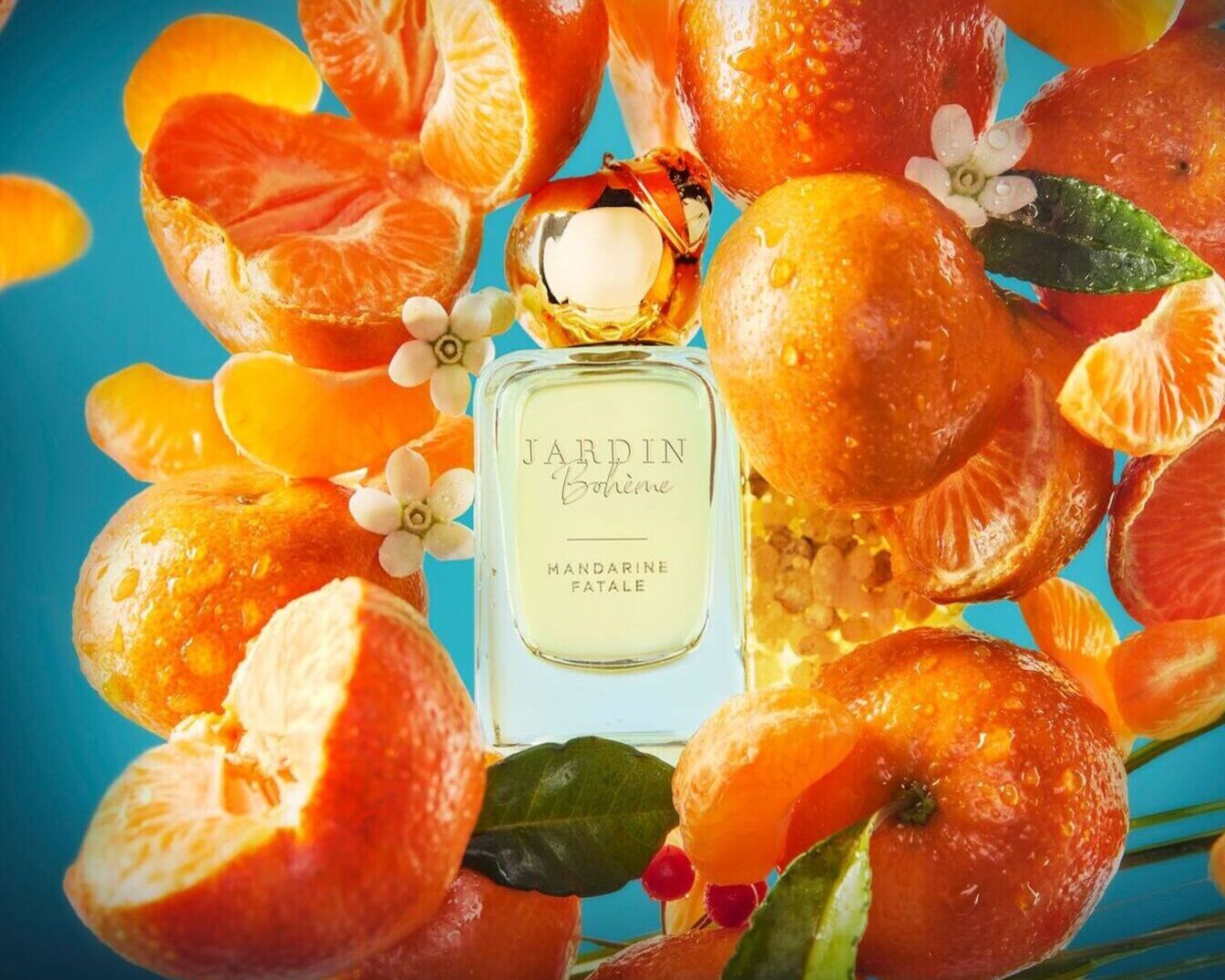 Kvepalų buteliukas „Jardin Bohème Mandarine Fatale“ apsuptas sultingų mandarinų ir baltų žiedų, sukuriančių gaivų ir viliojantį aromatą.