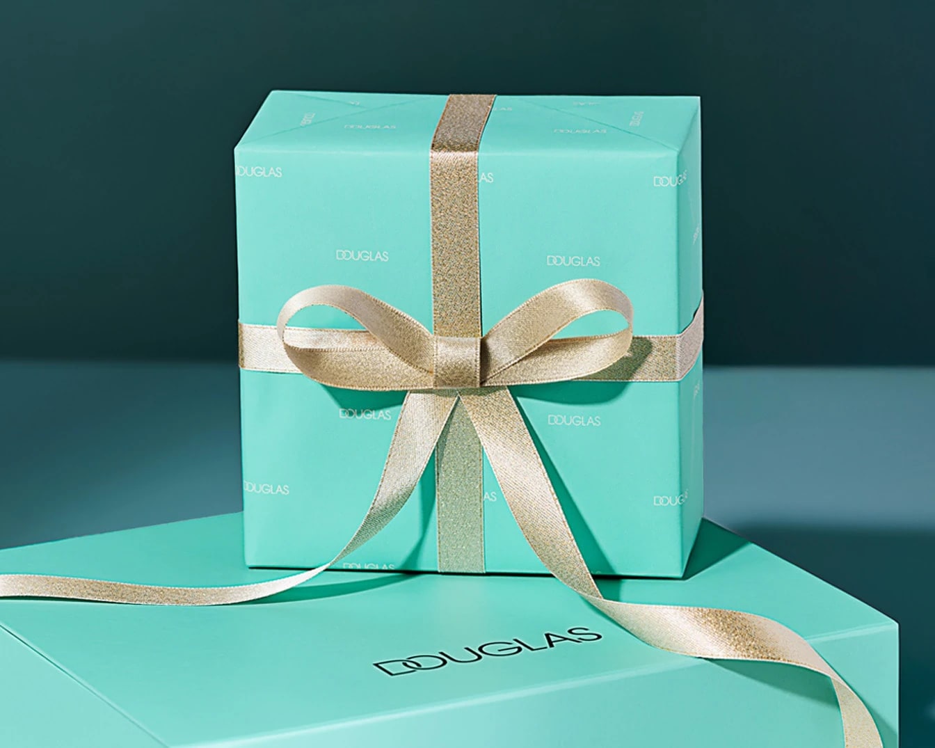 Błękitne pudełko prezentowe Douglas przewiązane złotą wstążką, idealne na każdą okazję.