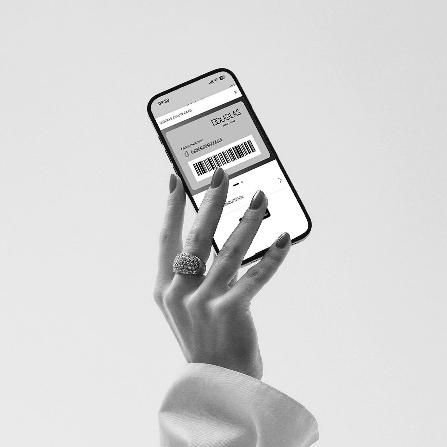 Elegancka dłoń trzyma telefon z aplikacją Douglas Beauty Card, prezentując cyfrową kartę lojalnościową.