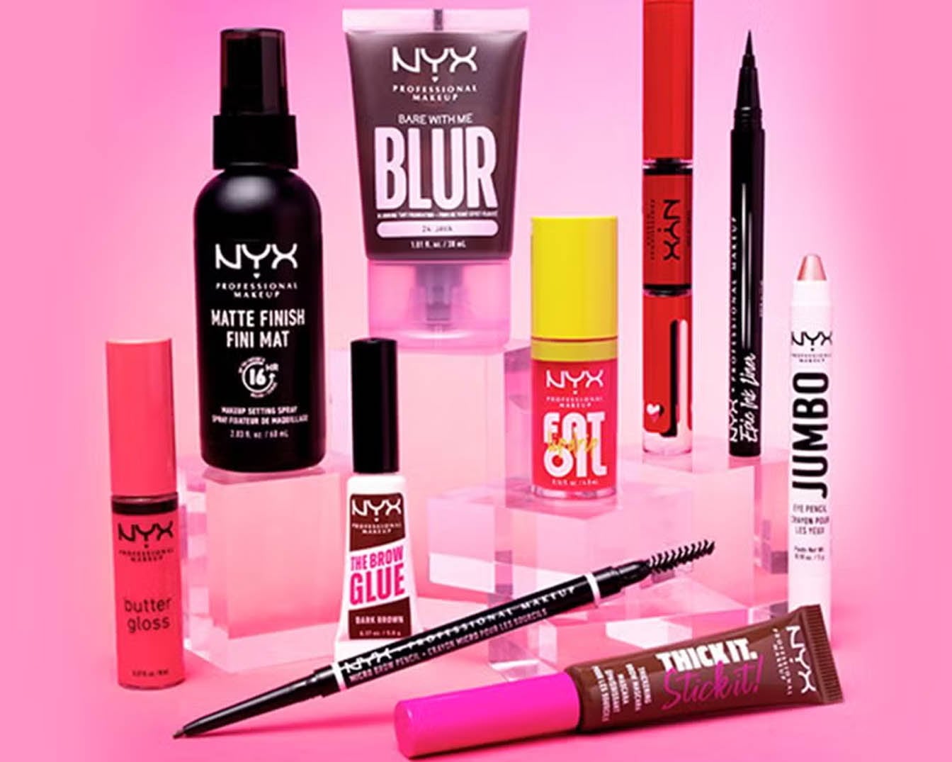 Różnorodność kosmetyków NYX Professional Makeup na różowym tle, w tym spray utrwalający, baza Blur, błyszczyk Butter Gloss i tusz do brwi The Brow Glue.