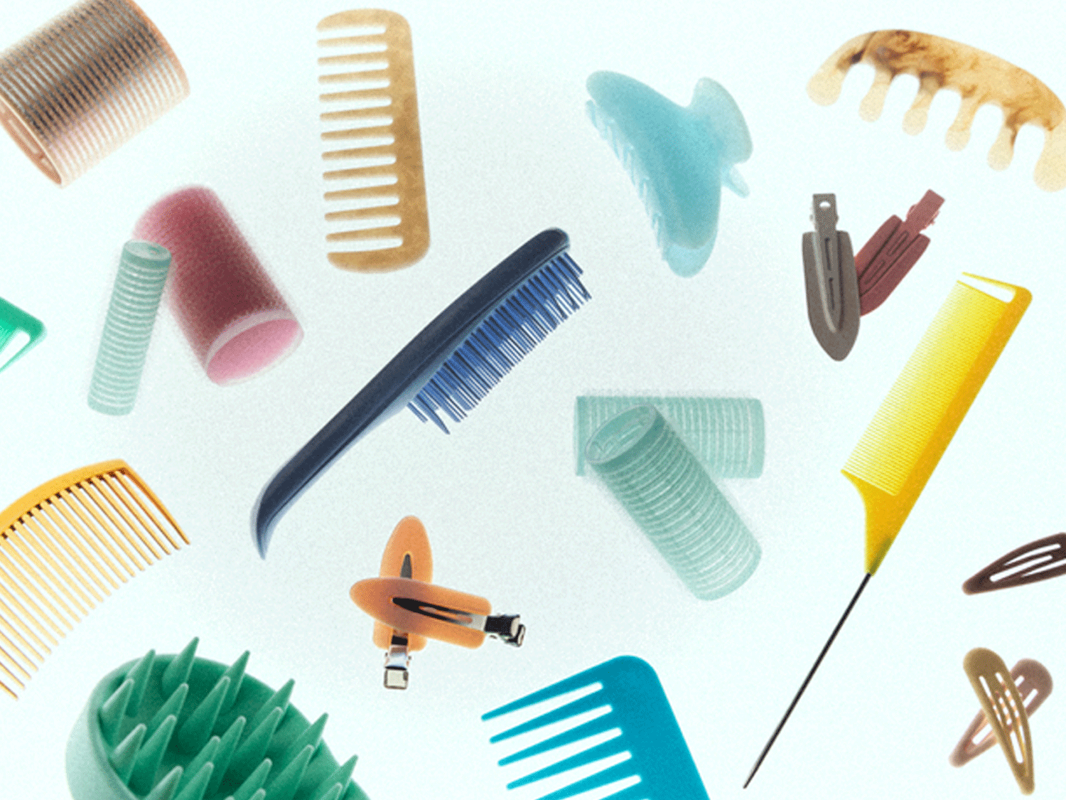 Verschiedene Parfümflaschen in Gold-, Rosa-, Grün- und Kristalltönen liegen auf einer hellen Oberfläche und werfen lange Schatten.