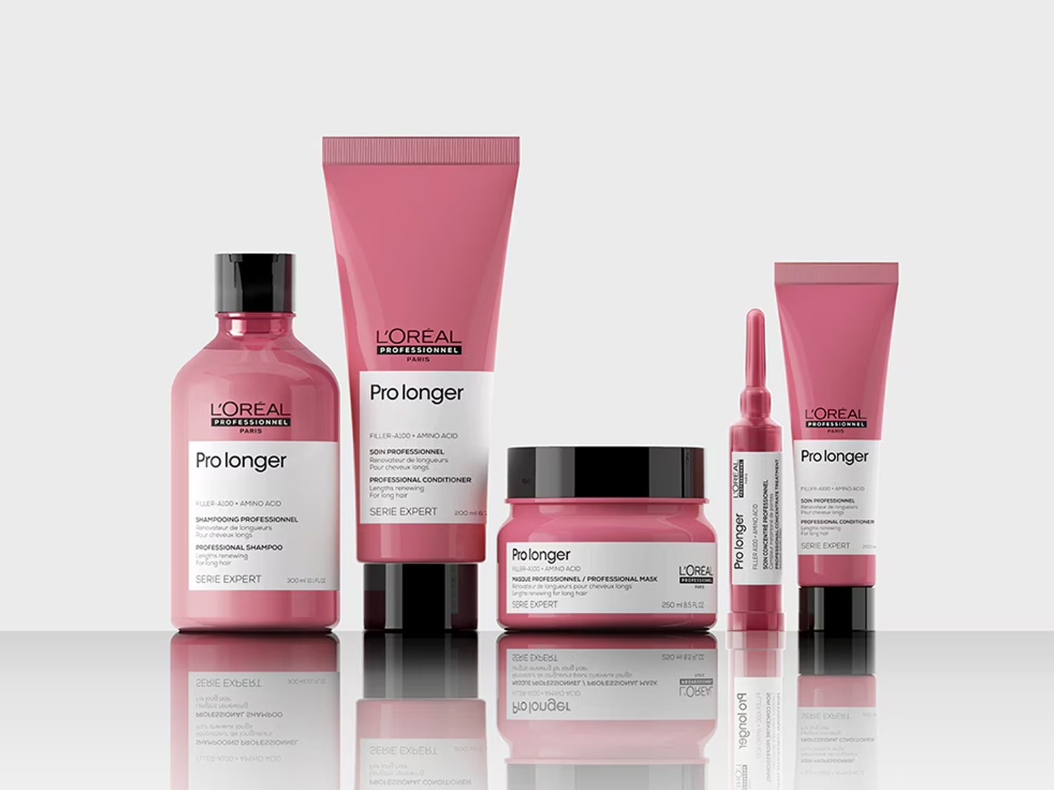 Różowa seria do włosów L'Oréal Professionnel Pro Longer, zawierająca szampon, odżywkę, maskę i koncentrat, zapewniająca odnowę długości włosów.