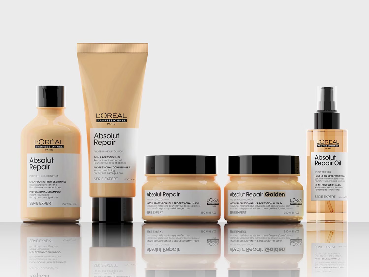 Seria produktów do włosów L'Oréal Professionnel Absolut Repair z proteinami i złotą komosą ryżową, obejmująca szampon, odżywkę, maskę i olejek, które zapewniają intensywną regenerację suchym i zniszczonym włosom.
