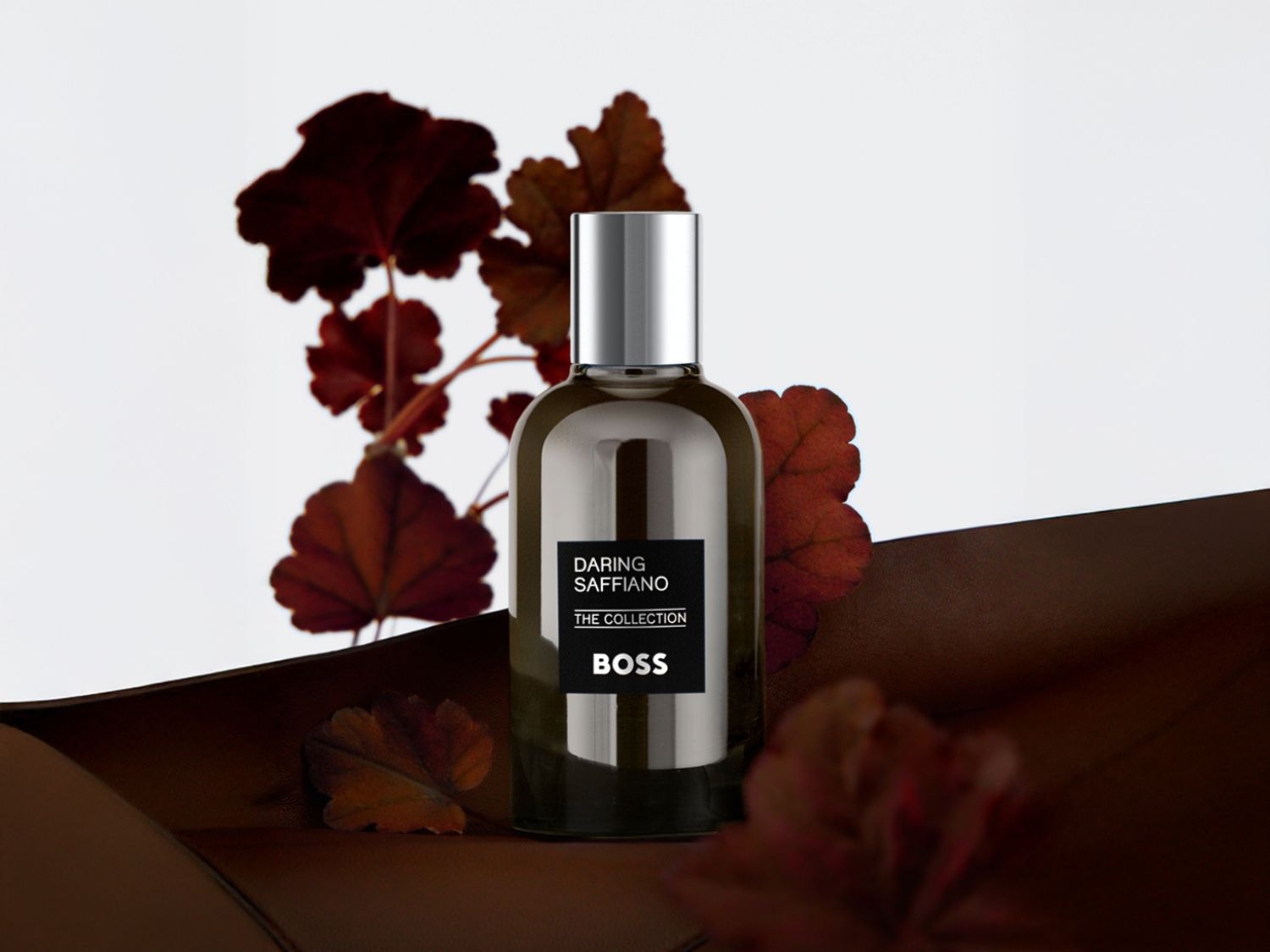 A Hugo Boss Alive parfümös üvege mélyvörös színben pompázik, arany színű kupakkal és ALIVE felirattal, virágokkal és arany levelekkel díszítve.