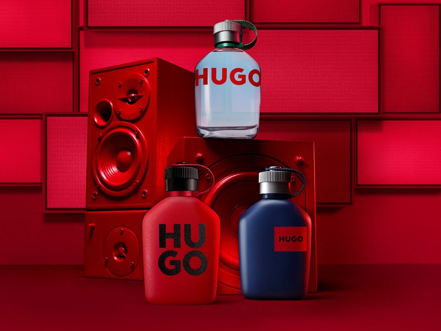 A HUGO Man Eau de Toilette üvegének képe, amelyet átlátszó akril blokkok vesznek körül, amelyek közül néhányban levendula, fenyőág és zöldalma szelet található.