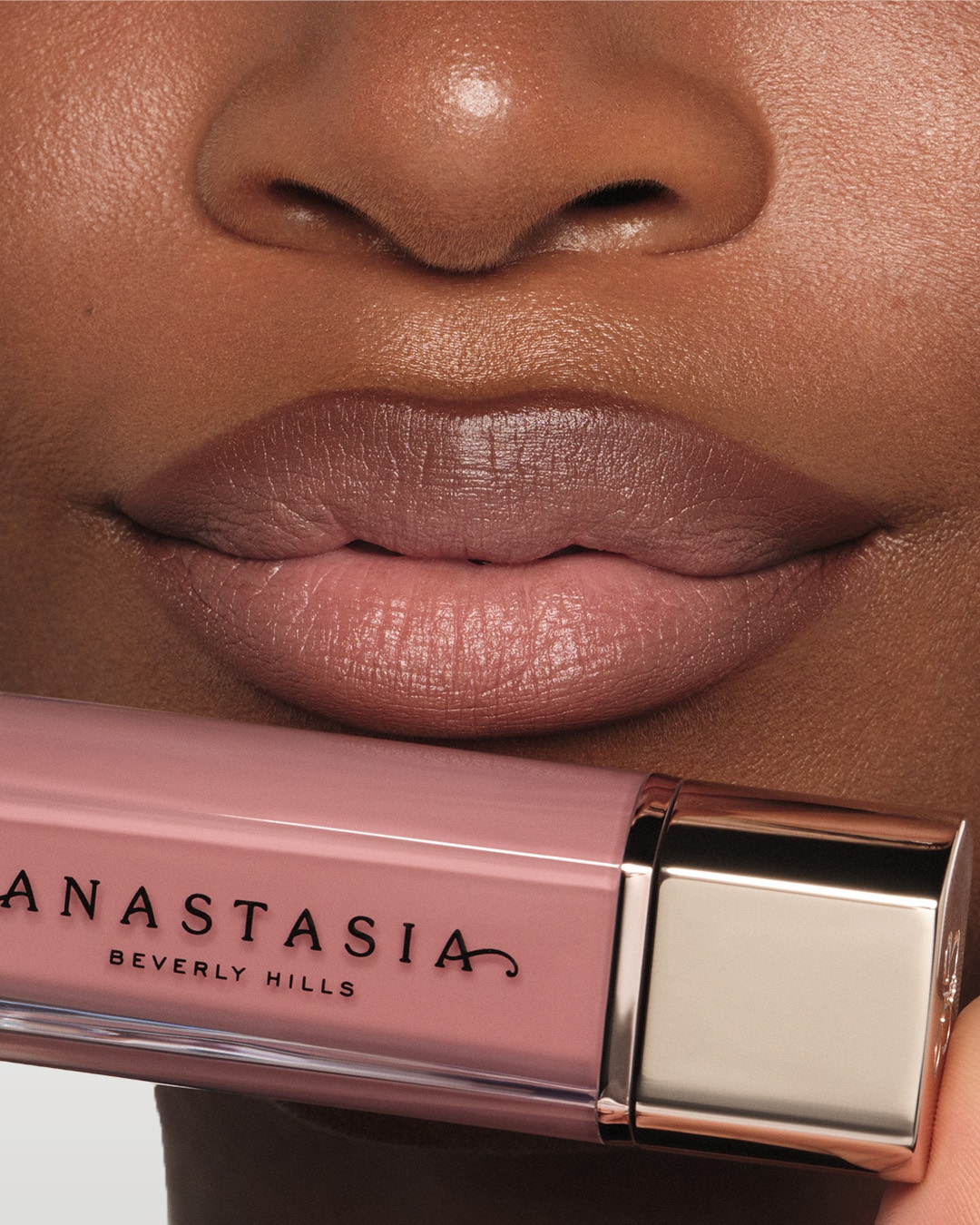 Gros plan sur des lèvres maquillées avec un rouge à lèvres rose nude d'Anastasia Beverly Hills, offrant un fini doux et une couleur subtile.