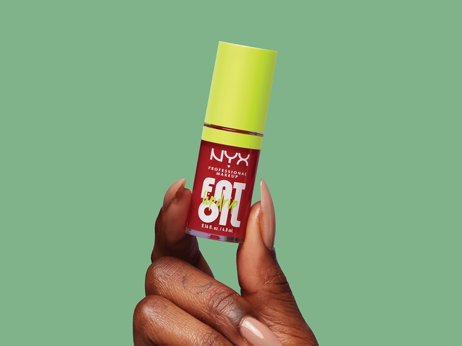 Une main tient un brillant à lèvres NYX rouge avec un bouchon jaune vif, offrant une touche de couleur et de brillance.