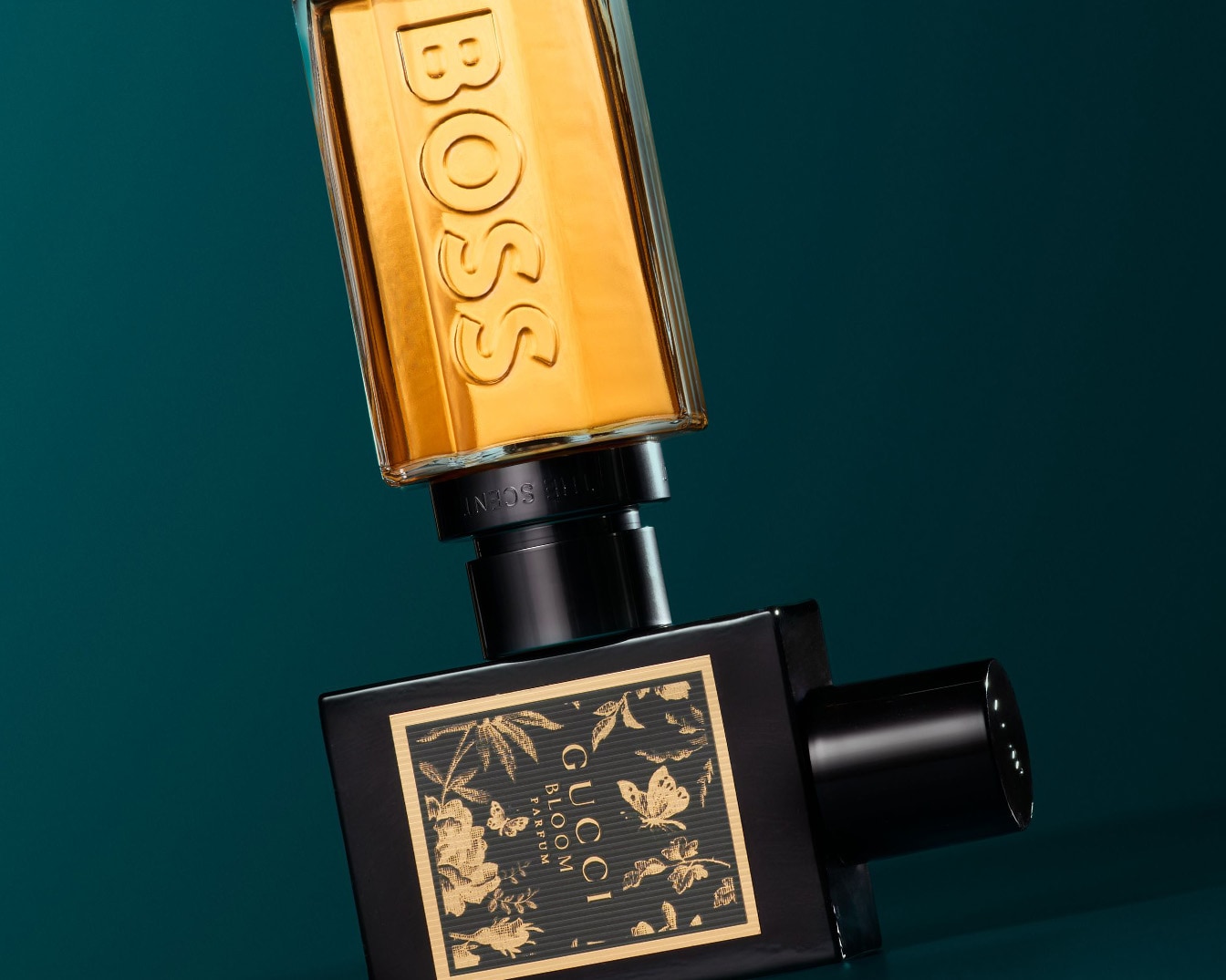 Présentation de deux parfums : un flacon doré BOSS et un flacon noir Gucci Bloom orné de motifs floraux dorés.
