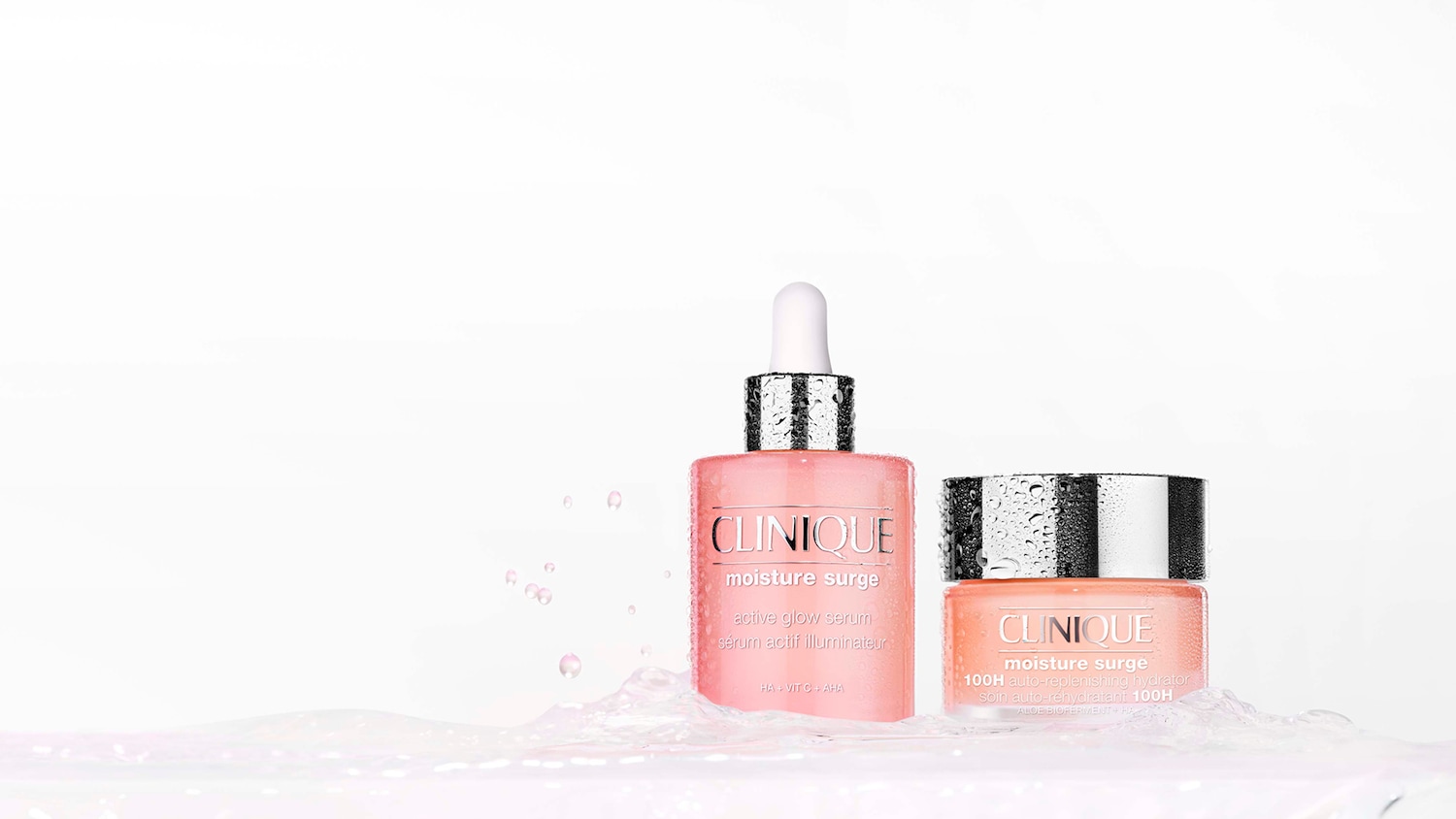 De Clinique Moisture Surge Active Glow Serum en 100H Auto-Replenishing Hydrator, beide in roze verpakkingen met zilveren doppen, staan in een spetterende waterplas.