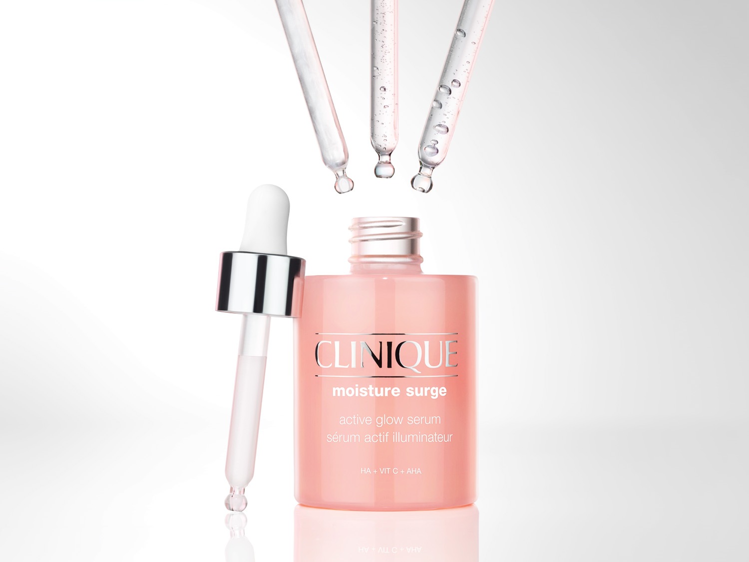 Nahaufnahme von Clinique Moisture Surge Active Glow Serum in einer hellrosa Glasflasche mit Pipette.