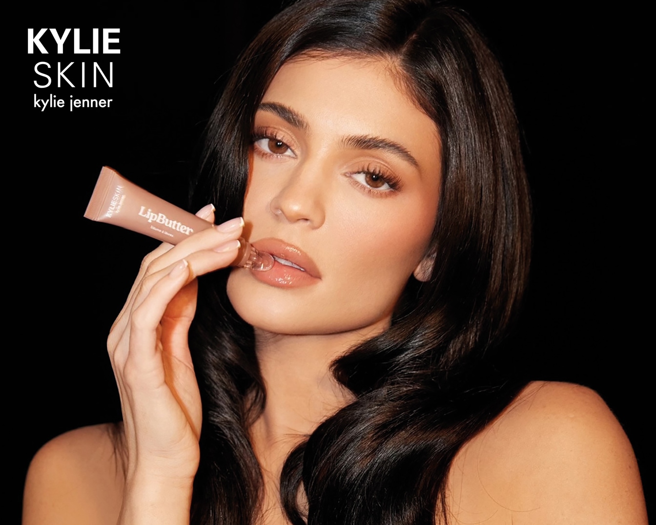 Kylie Jenner naudoja „Kylie Skin Lip Butter“ teptuką, kad suteiktų lūpoms drėkinimo ir blizgesio.