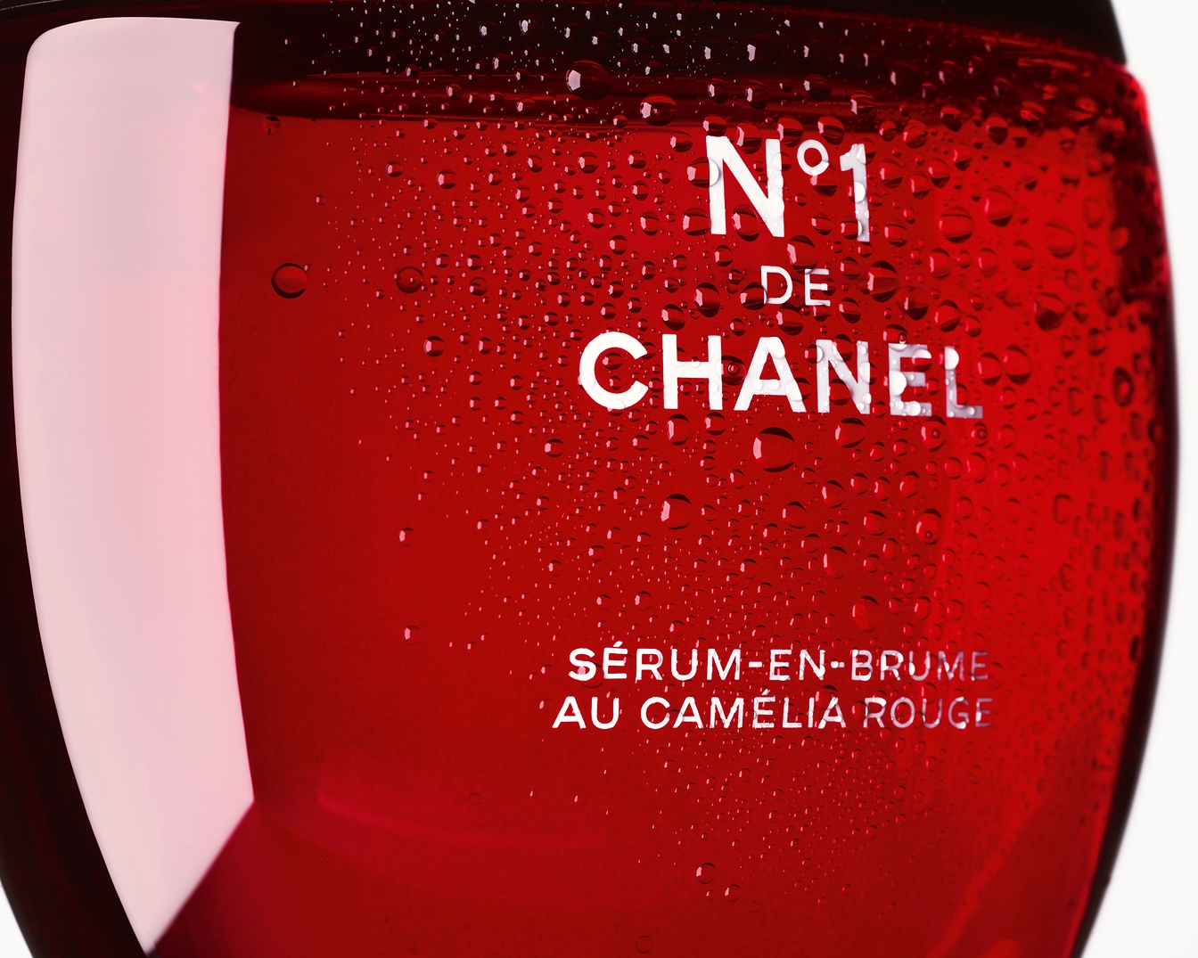 Découvrez le sérum-en-brume N°1 DE CHANEL au Camélia Rouge, un soin revitalisant dans un flacon rouge éclatant, parsemé de fines gouttelettes.