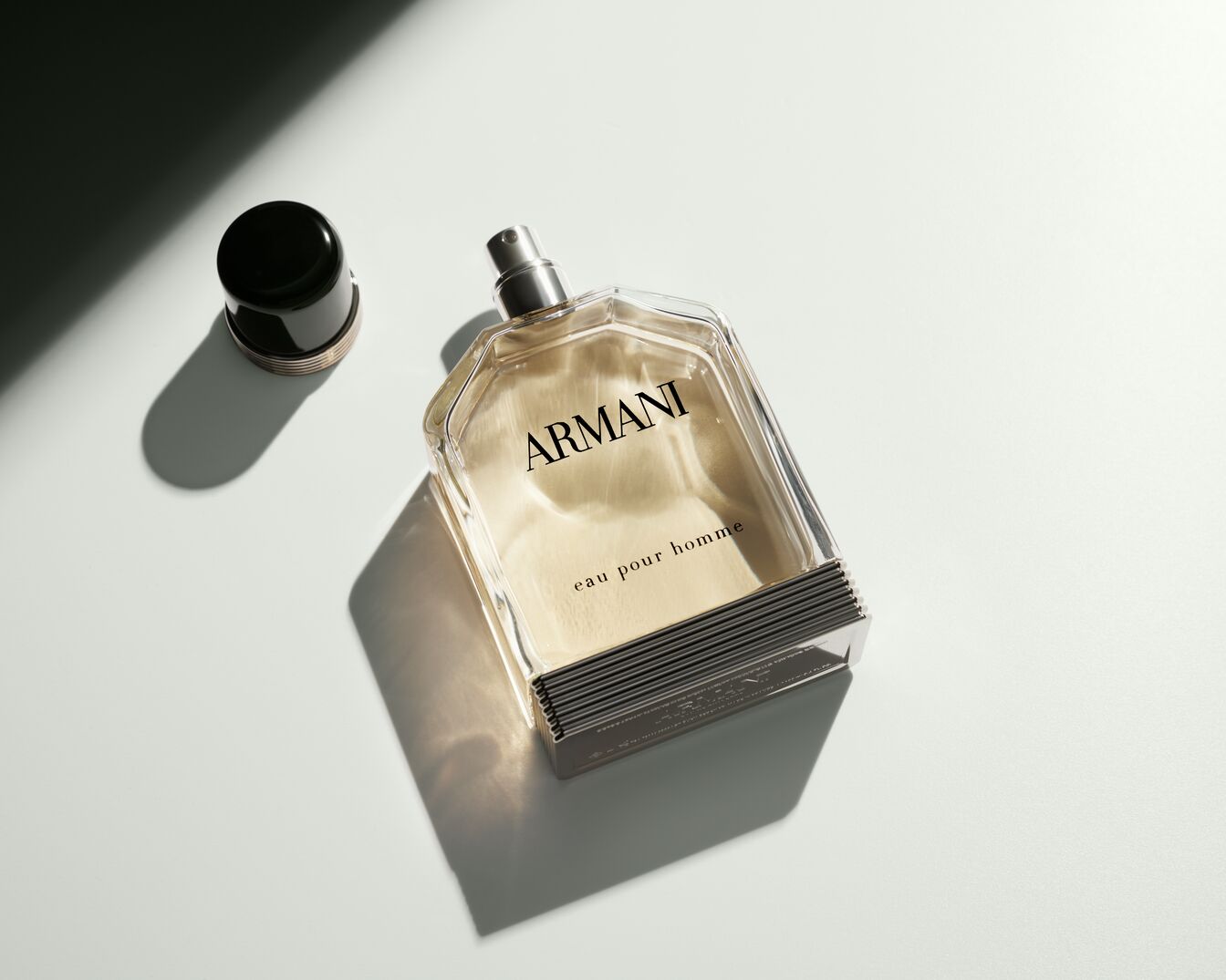 Découvrez le parfum Armani Eau pour Homme dans son flacon transparent distinctif, avec son bouchon noir élégant, offrant une senteur masculine et raffinée.
