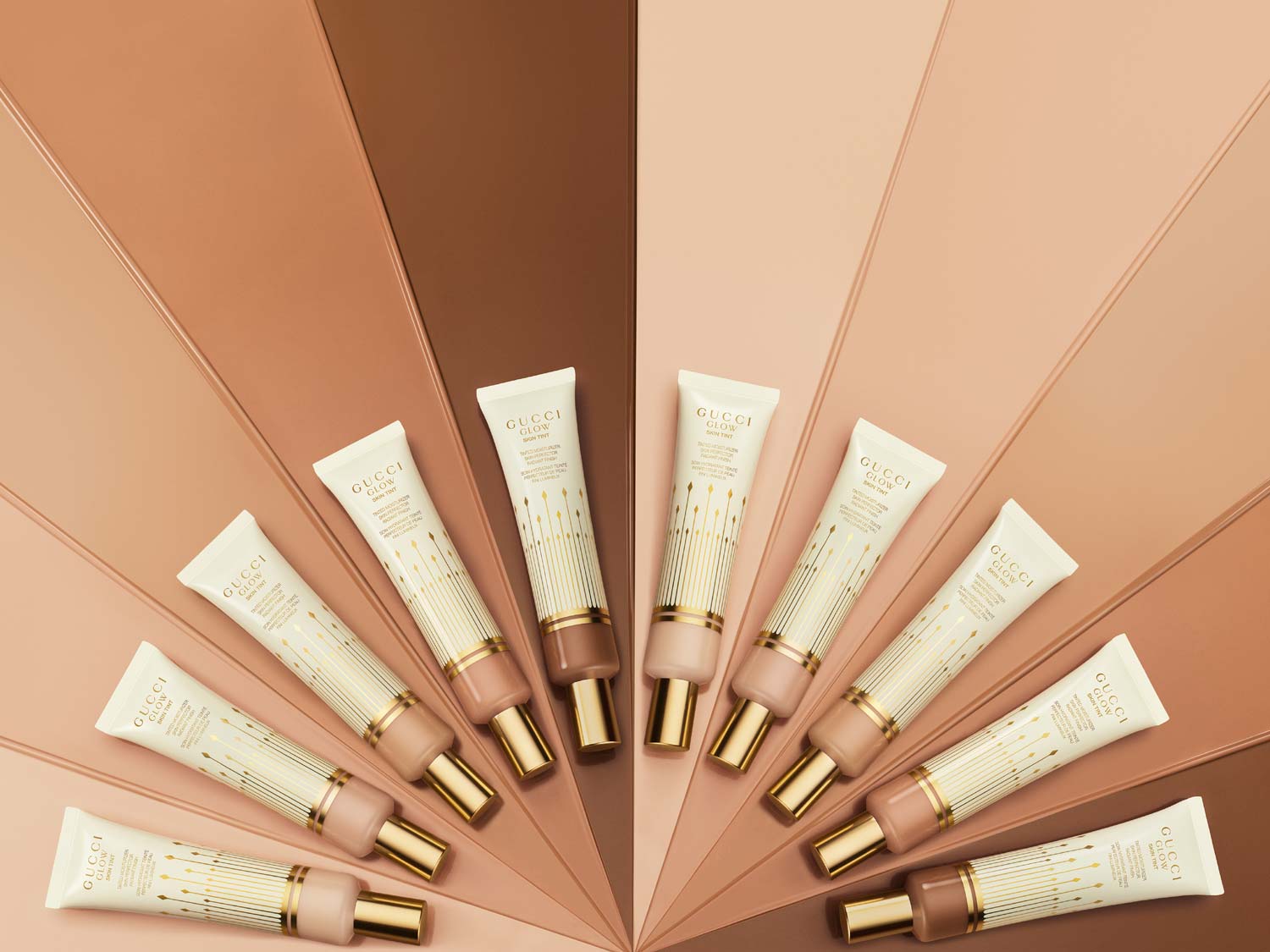 Ontdek Gucci Glow Skin Tint, verkrijgbaar in verschillende tinten, gepresenteerd in een witte tube met gouden details, voor een stralende teint.