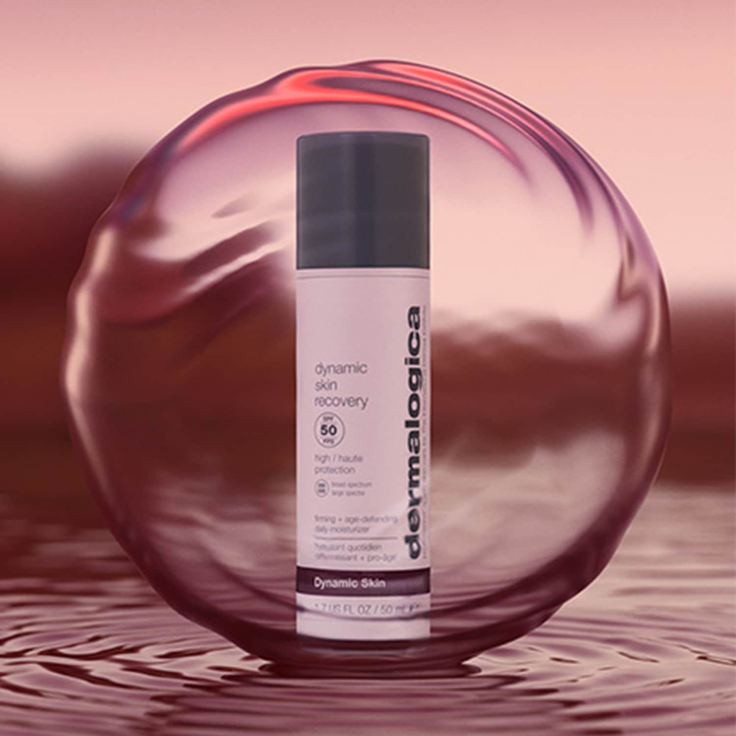Dermalogica Dynamic Skin Recovery SPF 50, eine straffende, feuchtigkeitsspendende Tagescreme in einer hellrosa Tube mit dunklem Deckel, umgeben von einer rosa Kugel.