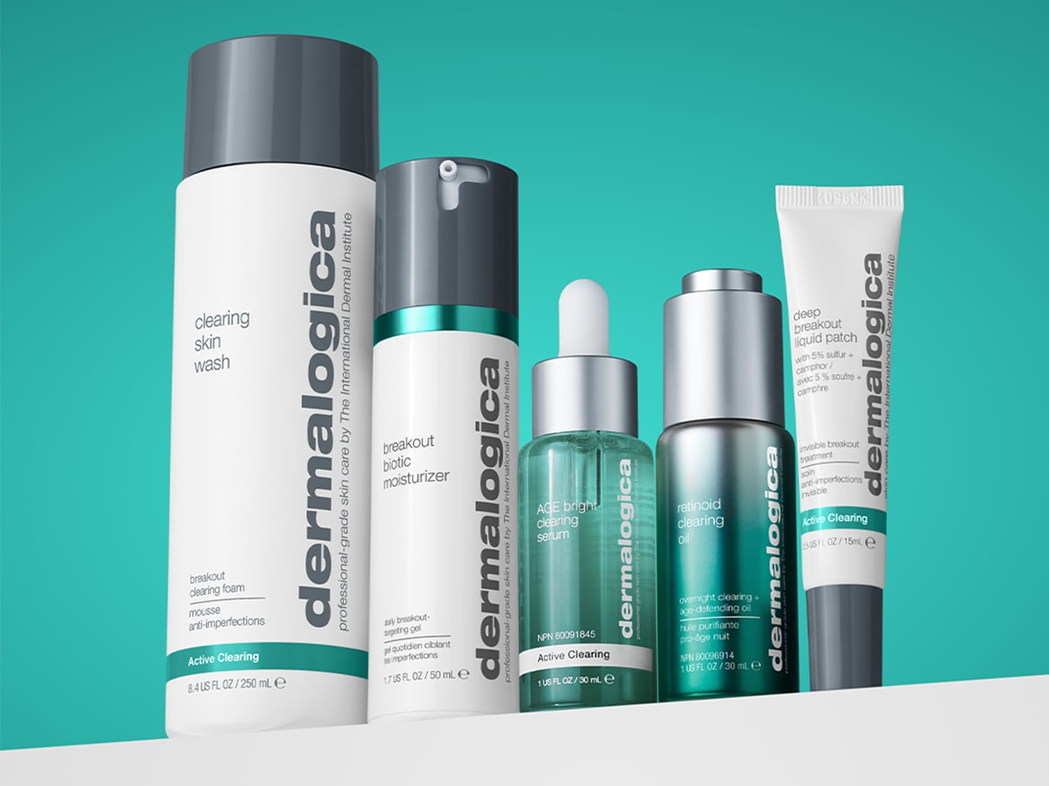 Eine Kollektion von Dermalogica Active Clearing Produkten, darunter Reinigungswäsche, Feuchtigkeitscreme, Serum, Öl und ein flüssiges Pflaster, die in weißen und grauen Flaschen mit grünen Akzenten präsentiert werden.