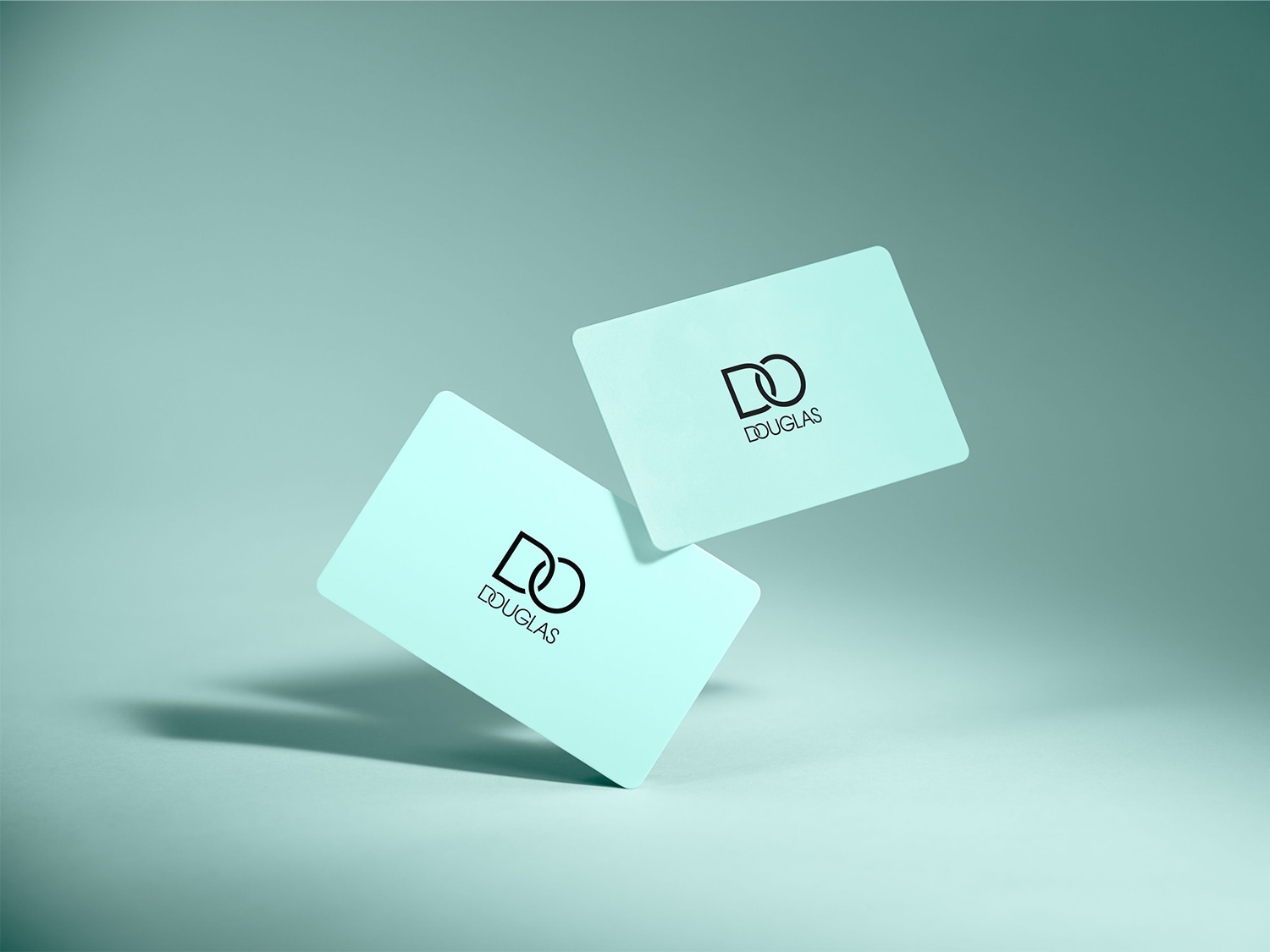 Twee lichtblauwe Douglas-cadeaubonnen met het Douglas-logo, de ene ligt op het oppervlak en de andere zweeft erboven.