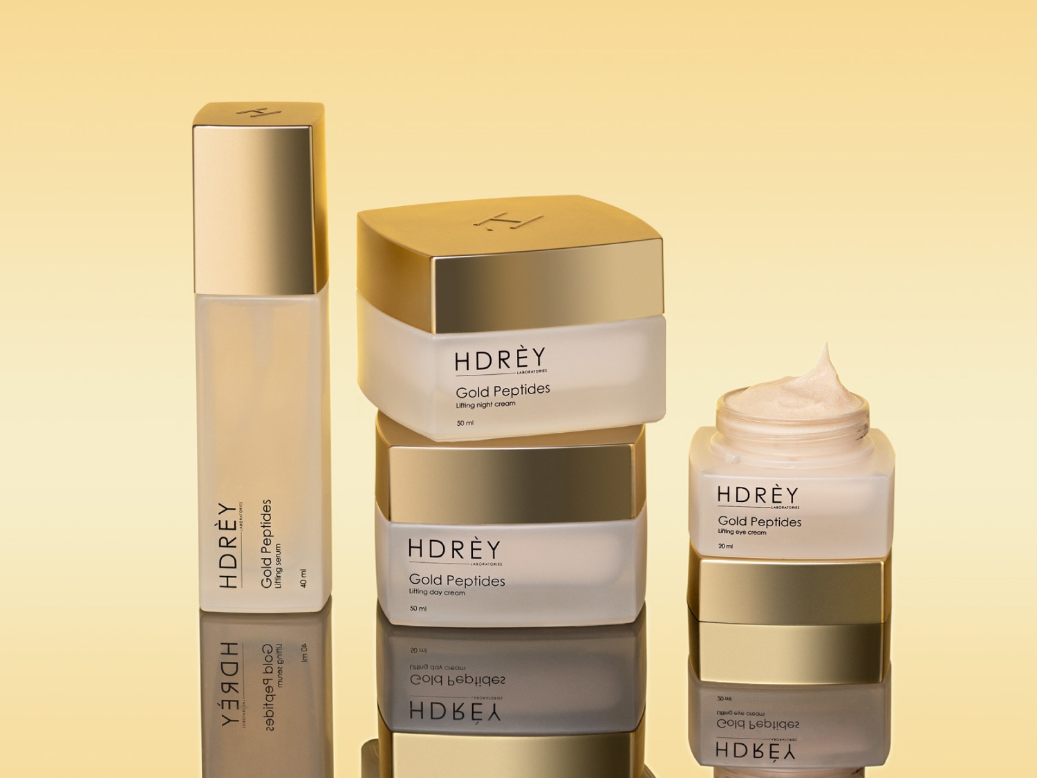 Kolekcja kosmetyków HDRÈY Gold Peptides w złotych opakowaniach: serum liftingujące, krem na noc i krem na dzień, zapewniające kompleksową pielęgnację skóry.