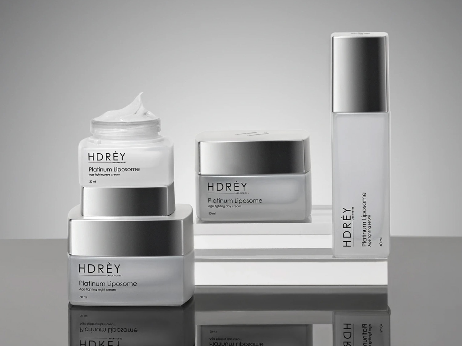 Kolekcja kosmetyków HDRÈY Platinum Liposome w białych opakowaniach: krem pod oczy, krem na dzień, krem na noc i serum przeciwstarzeniowe.