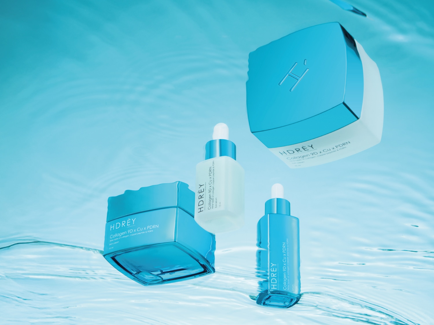 Kolekcja kosmetyków HDREY Collagen 9D x Cu x PDRN w błękitnych i białych opakowaniach, zawierająca krem do twarzy, serum pod oczy i inne produkty do pielęgnacji skóry.