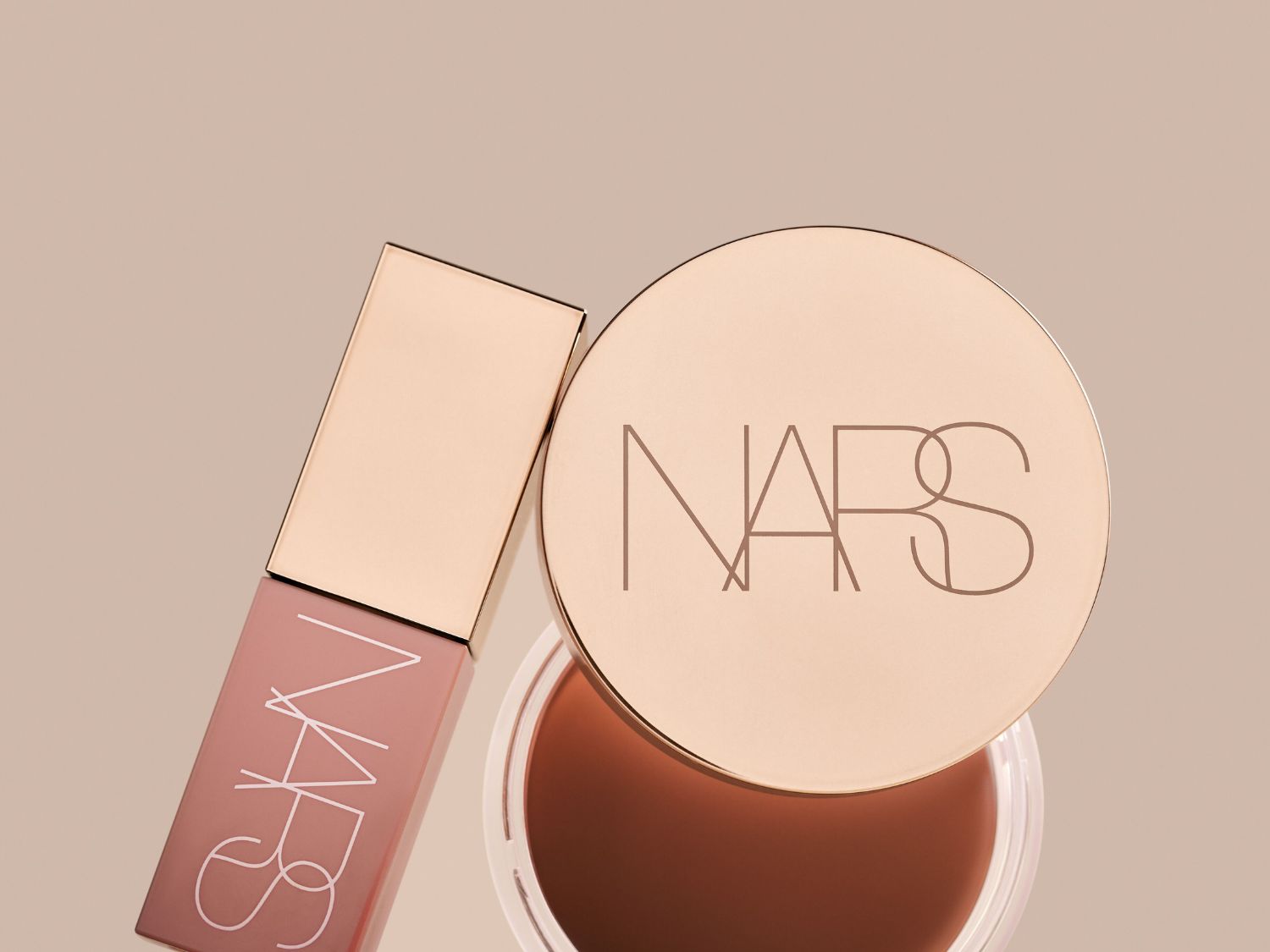 Découvrez le duo parfait de NARS : un brillant à lèvres rose tendre dans un emballage rectangulaire et un baume teinté dans un pot rond avec un couvercle doré portant le logo NARS.