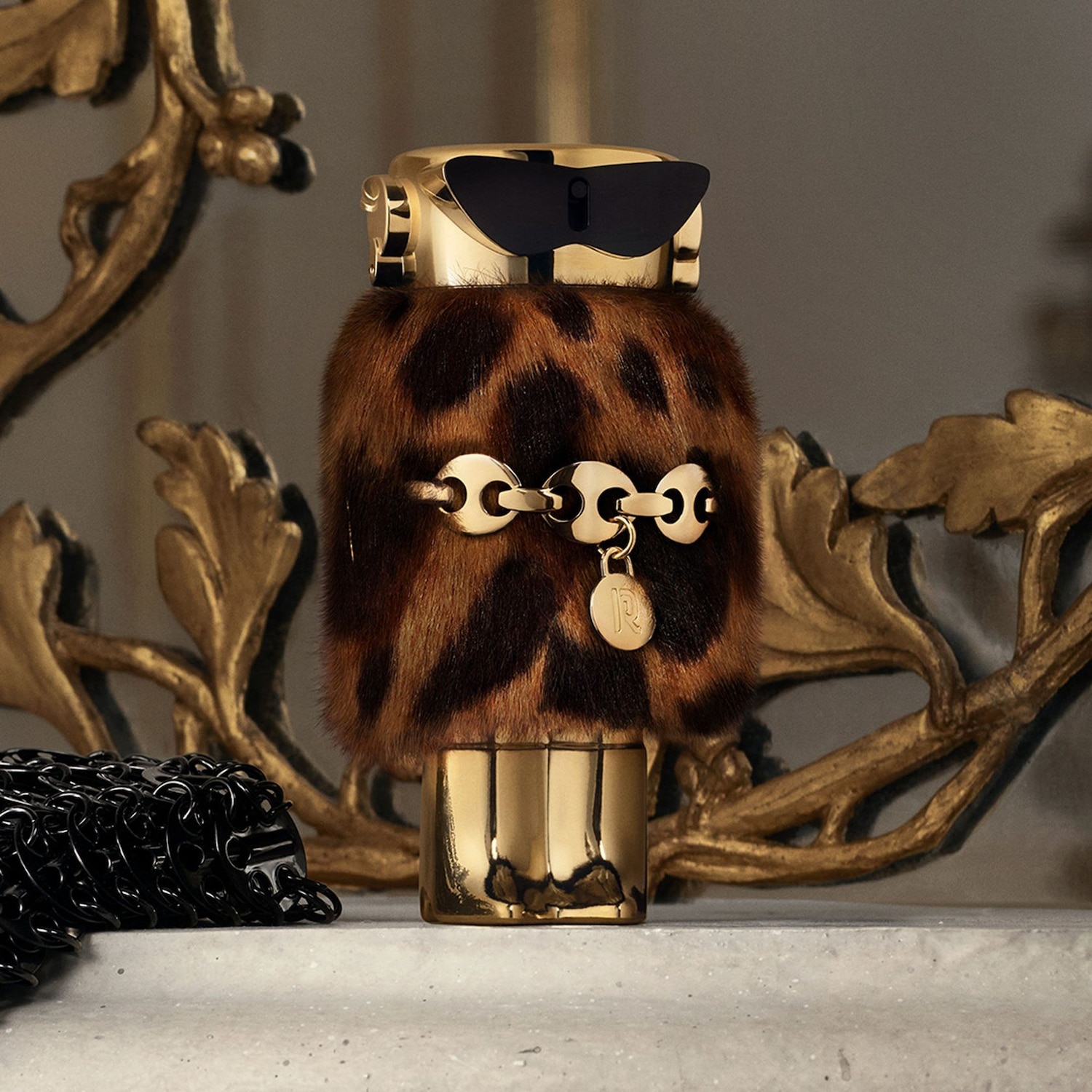 Flacon de parfum doré avec un motif léopard et des lunettes de soleil noires, évoquant un style audacieux et luxueux.