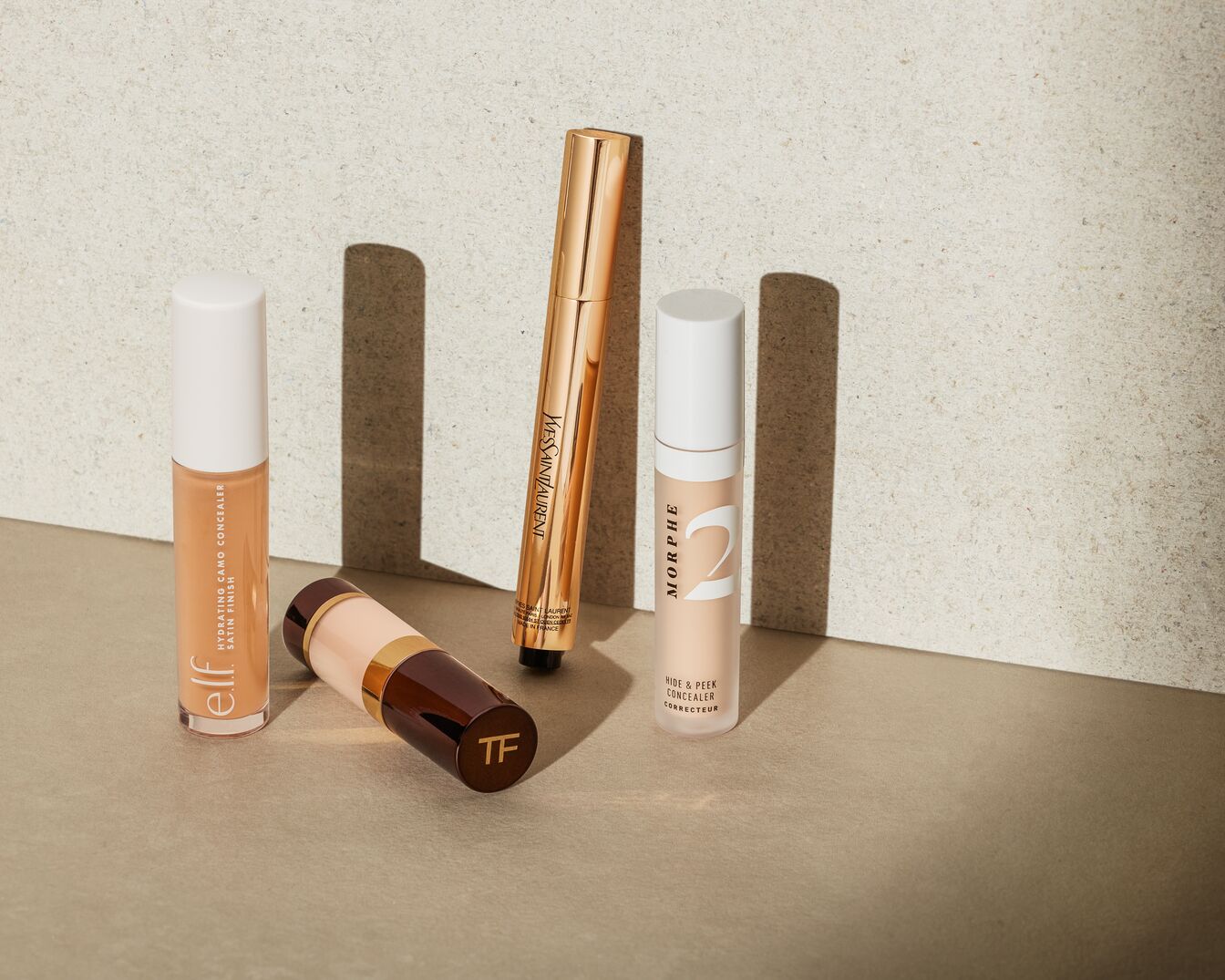 Ein Turm aus verschiedenen Farbtönen des Eye Optimizing Concealers in durchsichtigen Tiegeln mit schwarzen und roségoldenen Deckeln, die eine vollständige Abdeckung versprechen.