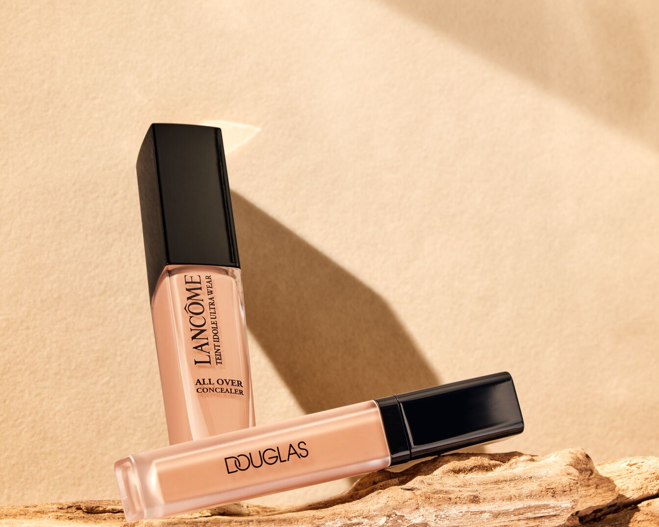 Douglas Eye Optimizing Concealer in einem durchsichtigen Glastiegel mit beiger Creme und schwarzem Deckel mit dem Douglas-Logo.