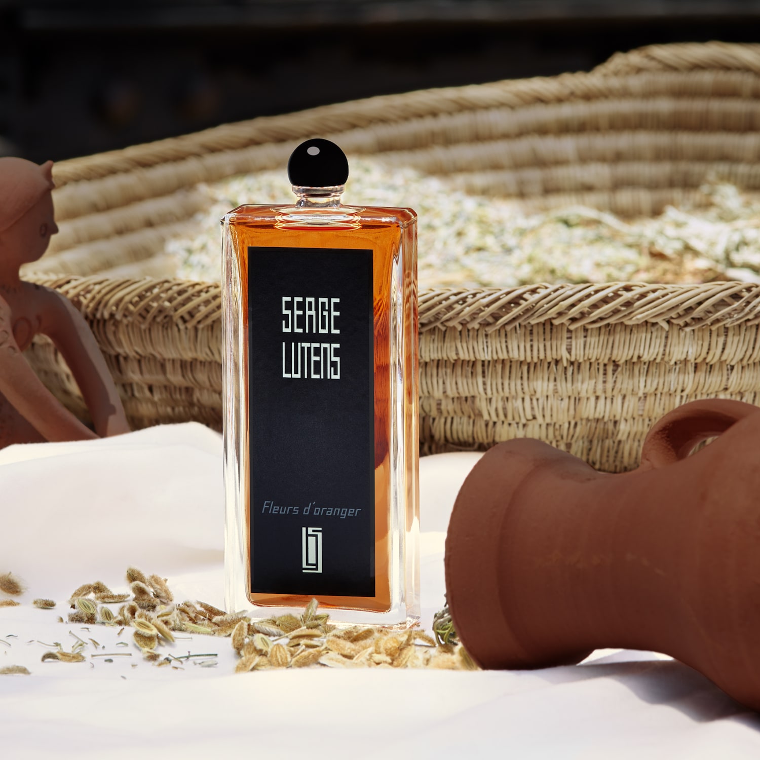 Découvrez le parfum Fleurs d'oranger de Serge Lutens, présenté dans un flacon transparent et élégant avec un bouchon noir, évoquant un luxe discret.