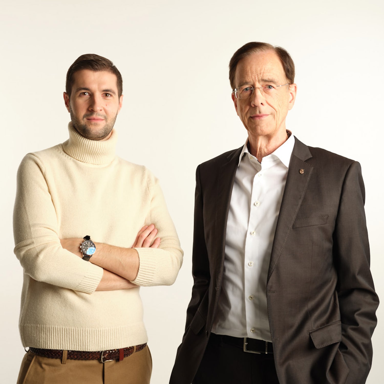 Zwei Männer stehen vor einem hellen Hintergrund.