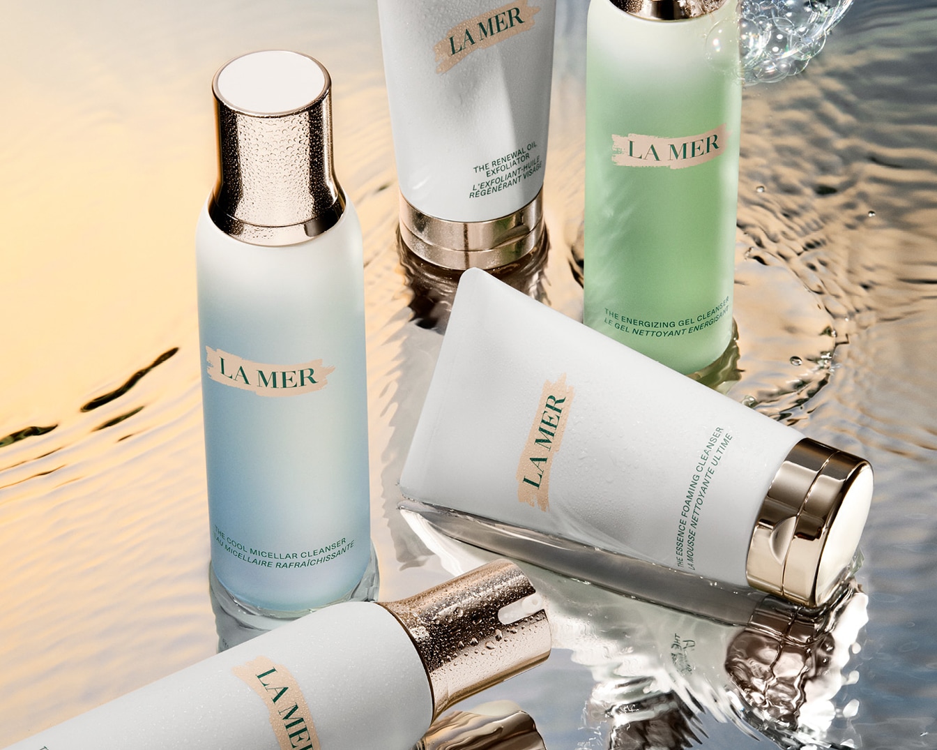 Ontdek La Mer's collectie van reinigingsproducten, waaronder micellair water, olie exfoliator, energie gel en schuimende reiniger, gepresenteerd in elegante verpakkingen.