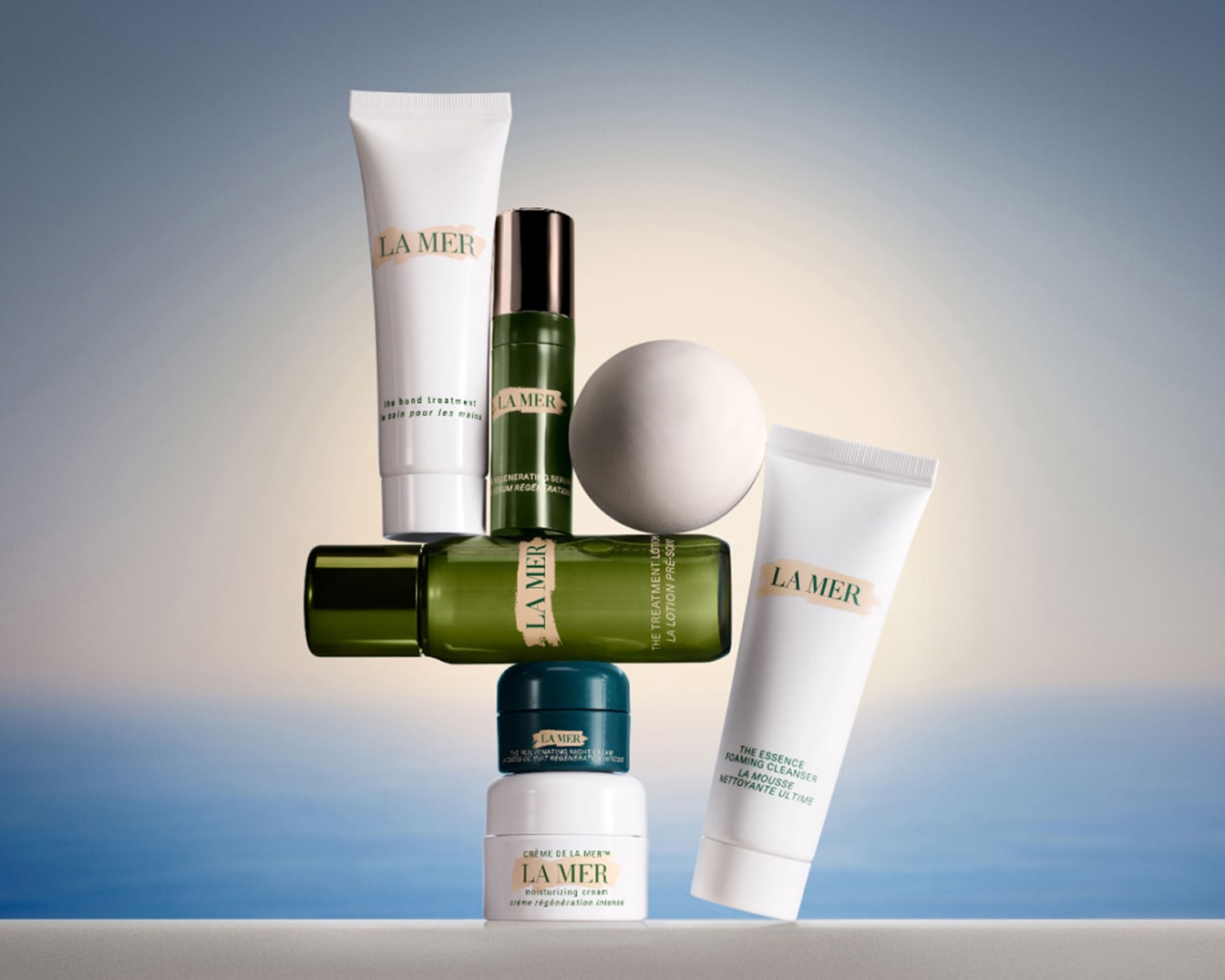 Een stapel La Mer huidverzorgingsproducten, waaronder crèmes, lotions en reinigers in witte en groene verpakkingen.