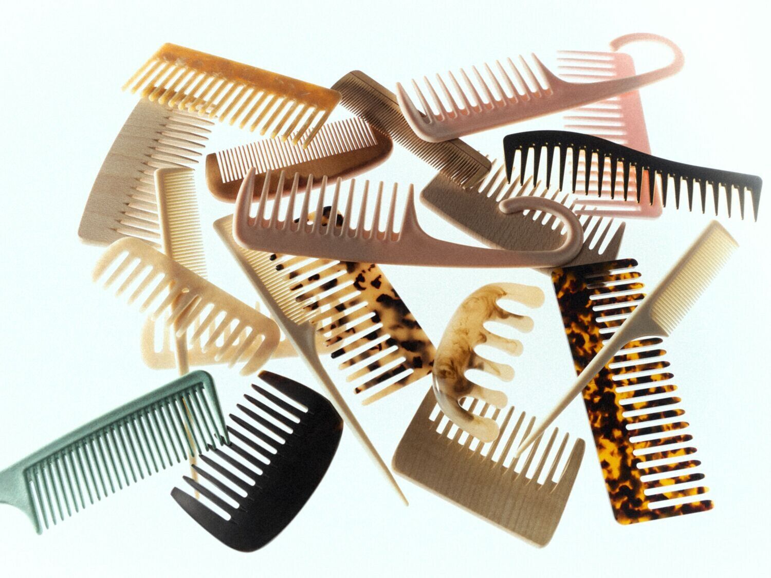 Įvairių spalvų ir formų šukų rinkinys, įskaitant vėžlio kiauto raštą, išdėstytas ant balto paviršiaus.