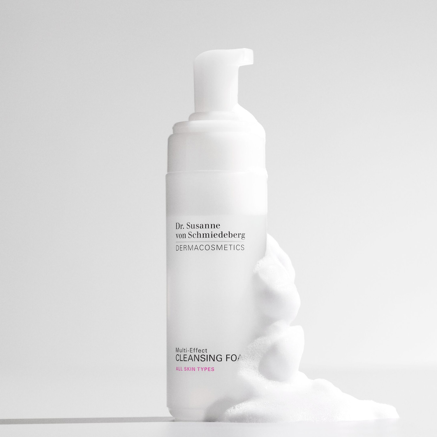 Voici le flacon blanc de la mousse nettoyante multi-effets Dr. Susanne von Schmiedeberg DERMACOSMETICS, adaptée à tous les types de peau, avec de la mousse blanche qui sort.