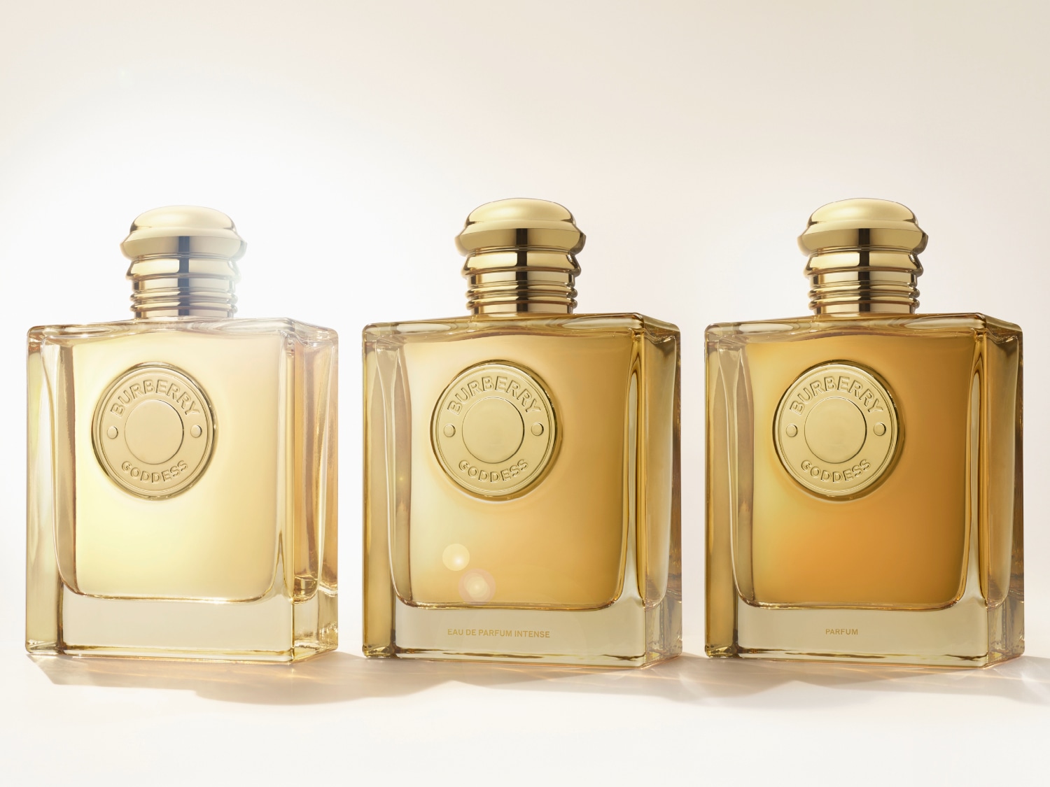 Dwa flakony perfum Burberry Goddess o bursztynowym zabarwieniu stoją na skale, prezentując elegancję i luksus.