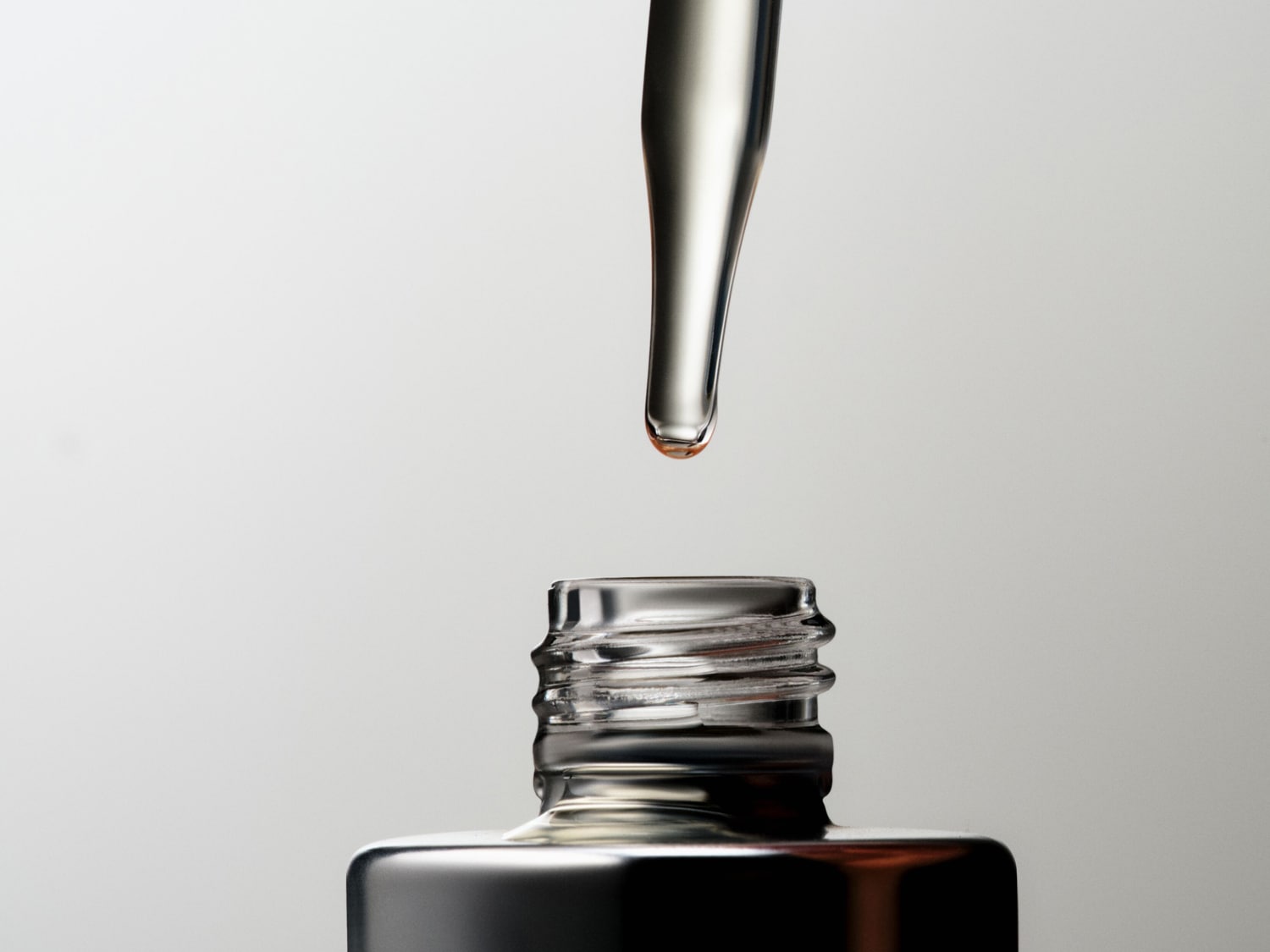 Verschiedene Hautpflegeprodukte, darunter The Inkey List Exosome Hydro-Glow Complex, Clinique Moisture Surge und OUAI Body Cleanser, die auf einem türkisfarbenen Hintergrund angeordnet sind.