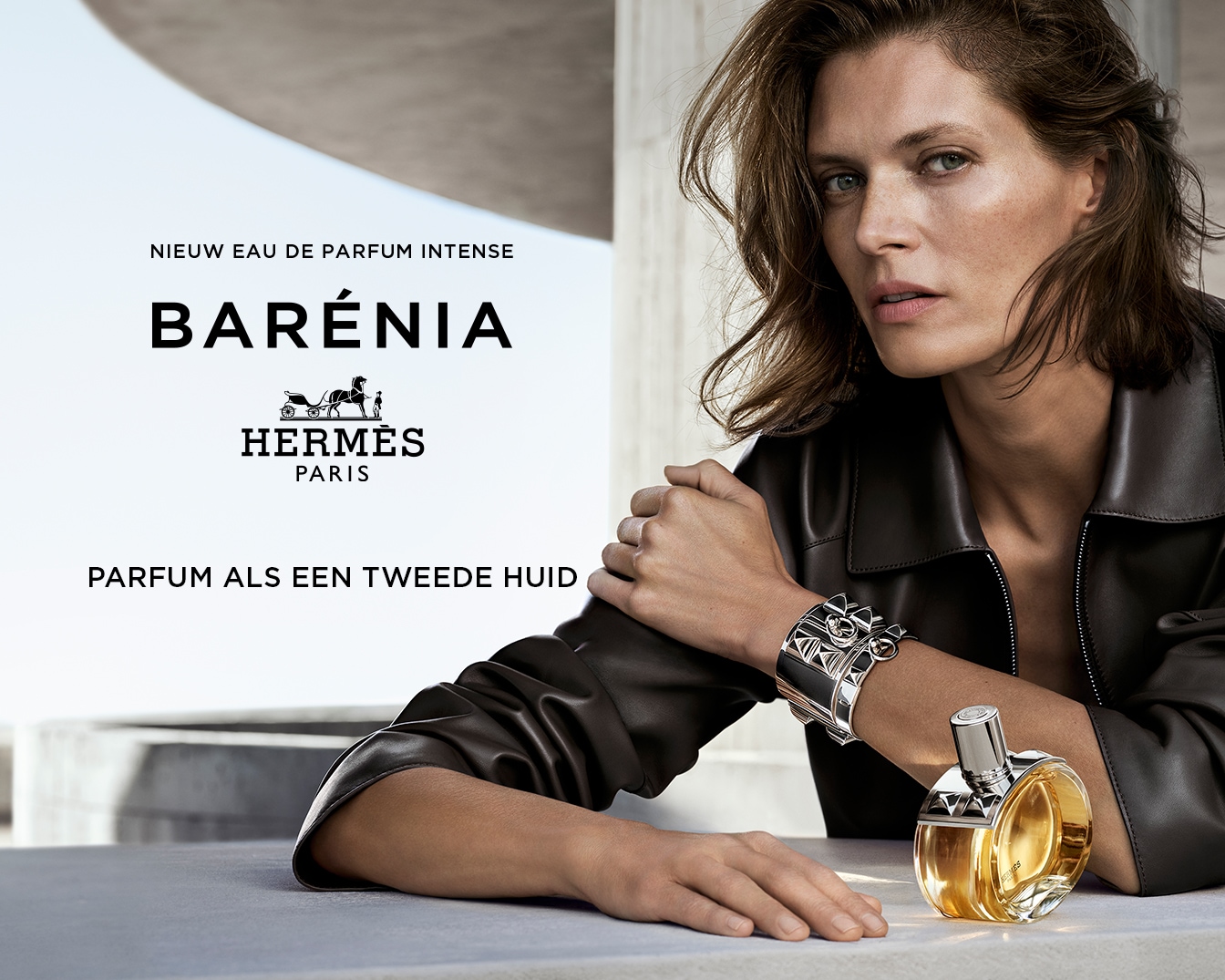 Nieuw Eau de Parfum Intense: Barénia van Hermès, een parfum als een tweede huid, gepresenteerd naast een vrouw met een zwarte leren jas en een zilveren armband.