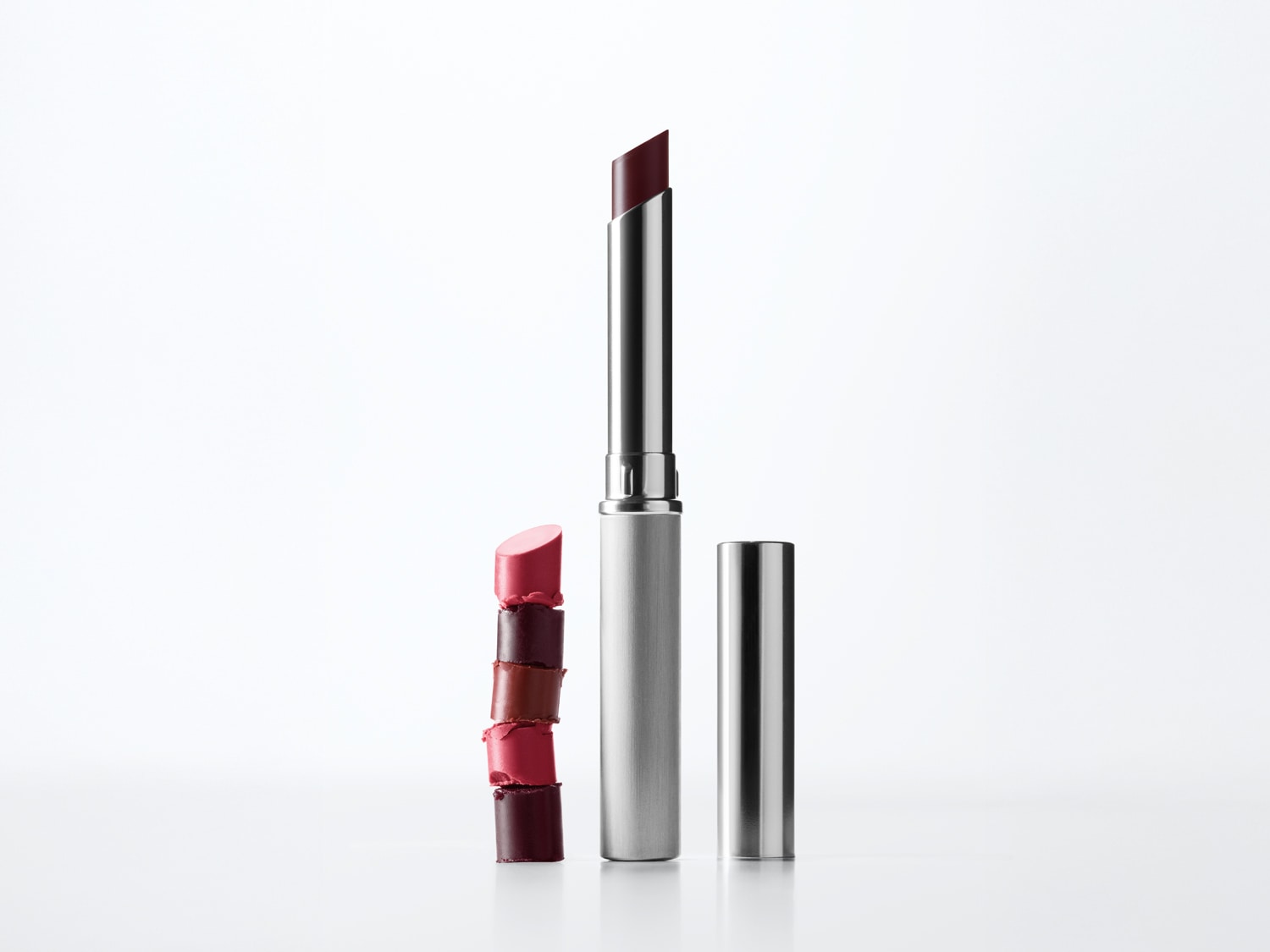 Découvrez ce rouge à lèvres élégant dans son tube argenté, avec un échantillon de nuances allant du rose délicat au bordeaux profond, parfait pour toutes les occasions.