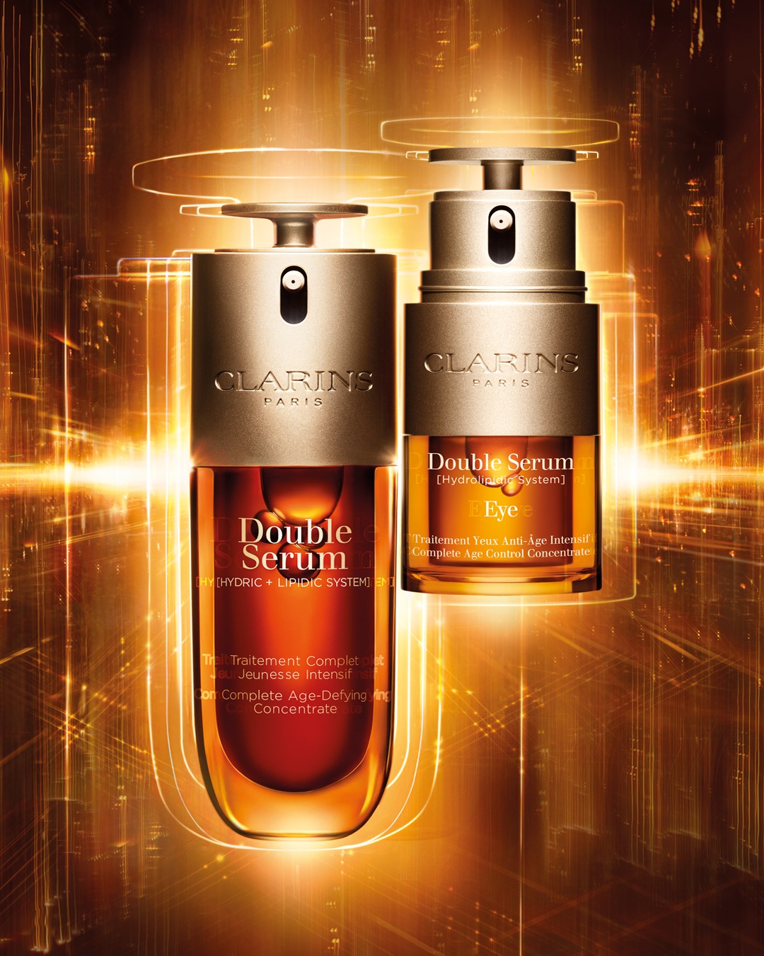 Twee Clarins Double Serum-flessen, één voor het gezicht en één voor de ogen, beide met gouden accenten en een luxe uitstraling.