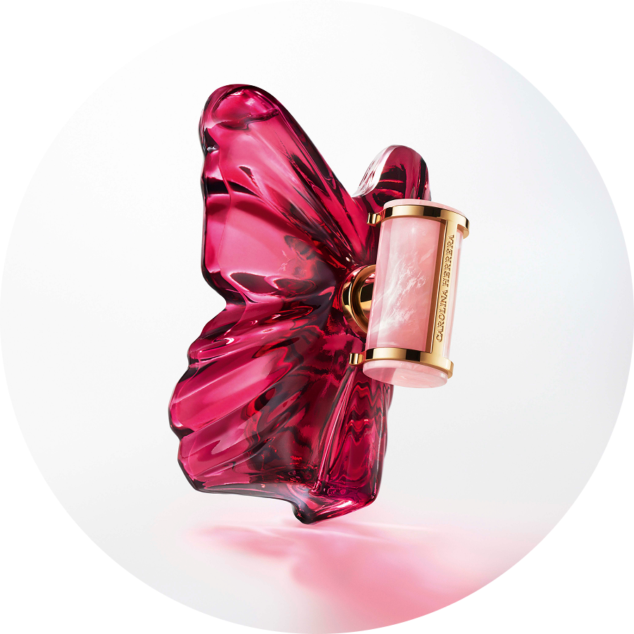 Butelka perfum Carolina Herrera w kształcie różowego motyla z akcentami w kolorze złota, emanująca luksusem i kobiecością.