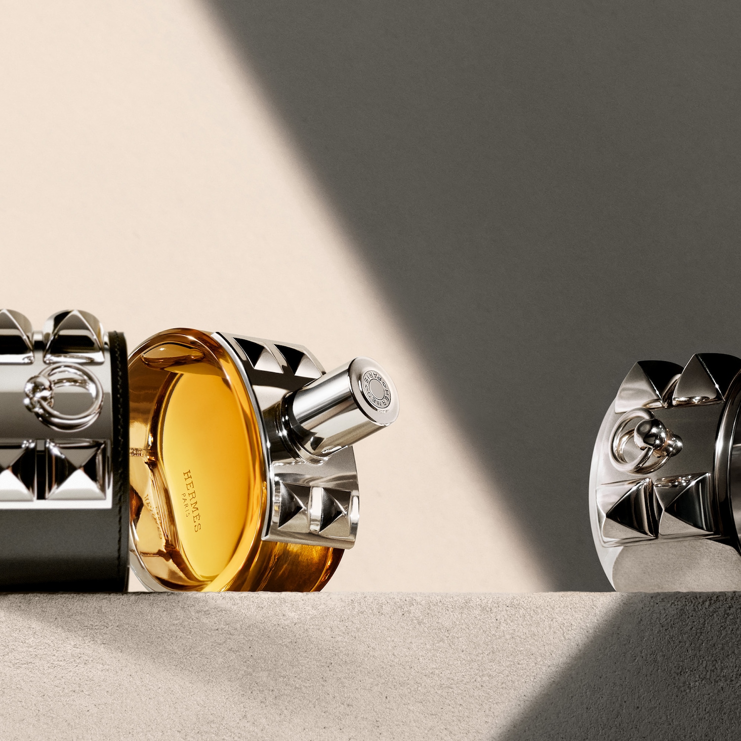 Nahaufnahme von Hermès Paris Parfum in einem transparenten Flakon mit silberfarbenen Akzenten, die auf einer hellen Oberfläche stehen.