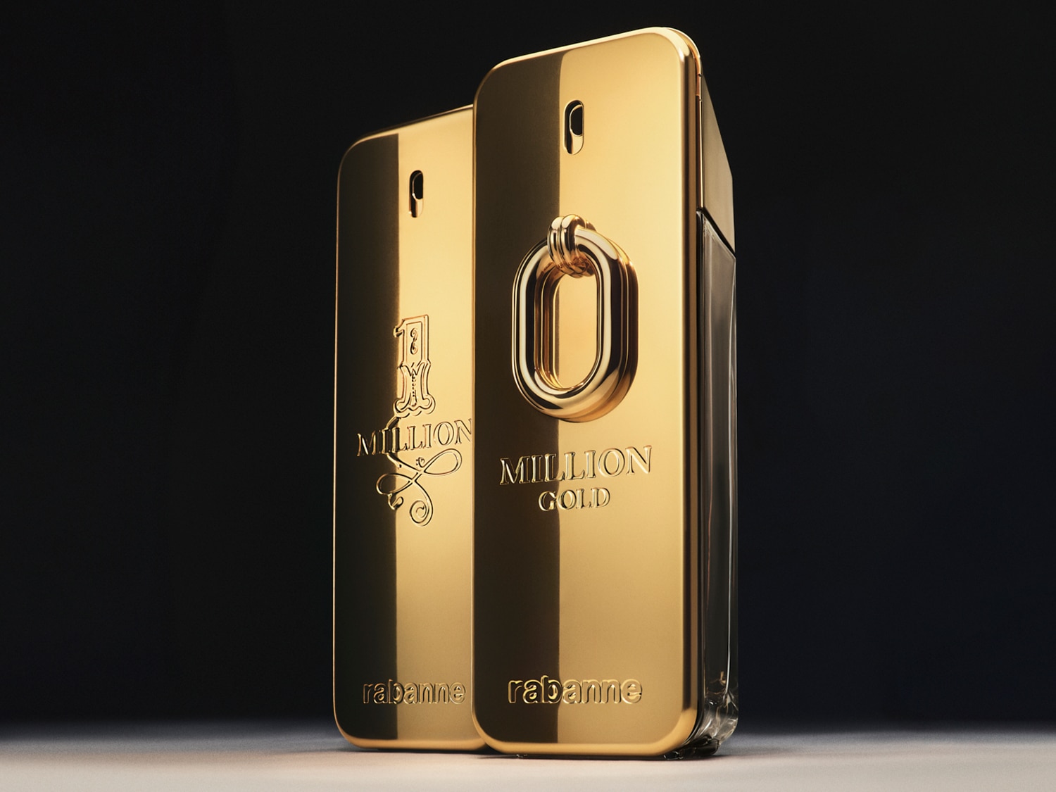 Dwa flakony perfum Rabanne 1 Million, jeden klasyczny i jeden w wersji Gold, oba w złotych, metalicznych opakowaniach w kształcie sztabki złota.