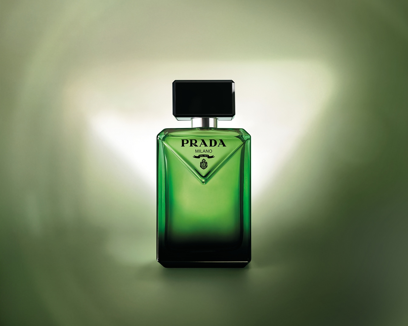 Découvrez le parfum Prada dans un flacon vert émeraude élégant avec un bouchon noir brillant, symbole de luxe et de sophistication.