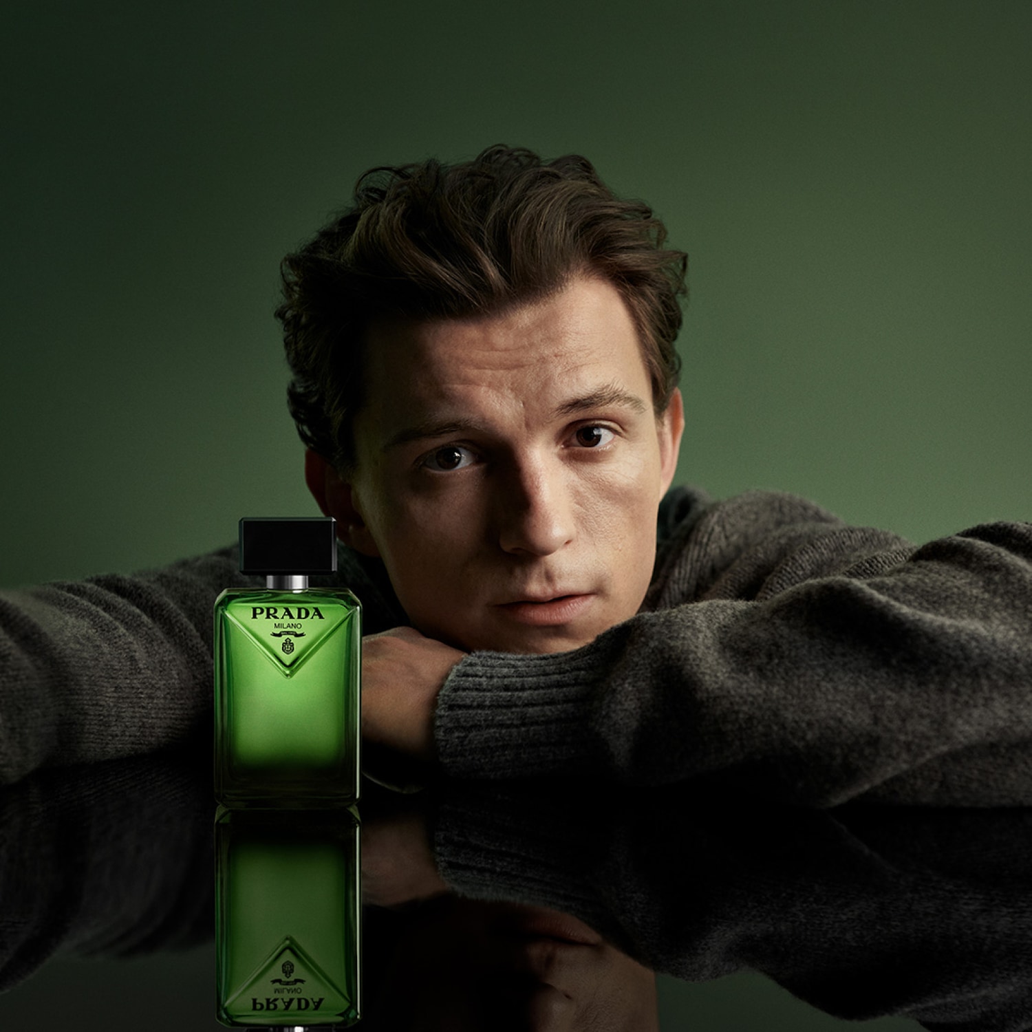 Tom Holland présente le parfum Prada dans un flacon vert émeraude élégant, reflétant une sophistication moderne.