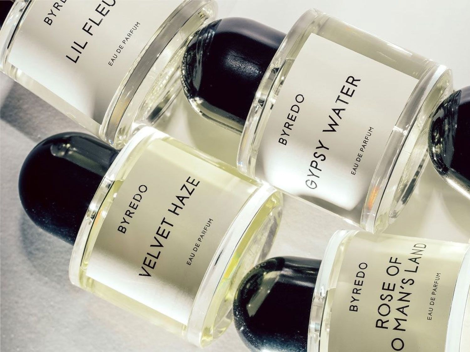 Kolekcja wód perfumowanych Byredo w szklanych flakonach z czarnymi korkami, w tym Velvet Haze, Gypsy Water, Rose of No Man's Land i Lil Fleur.