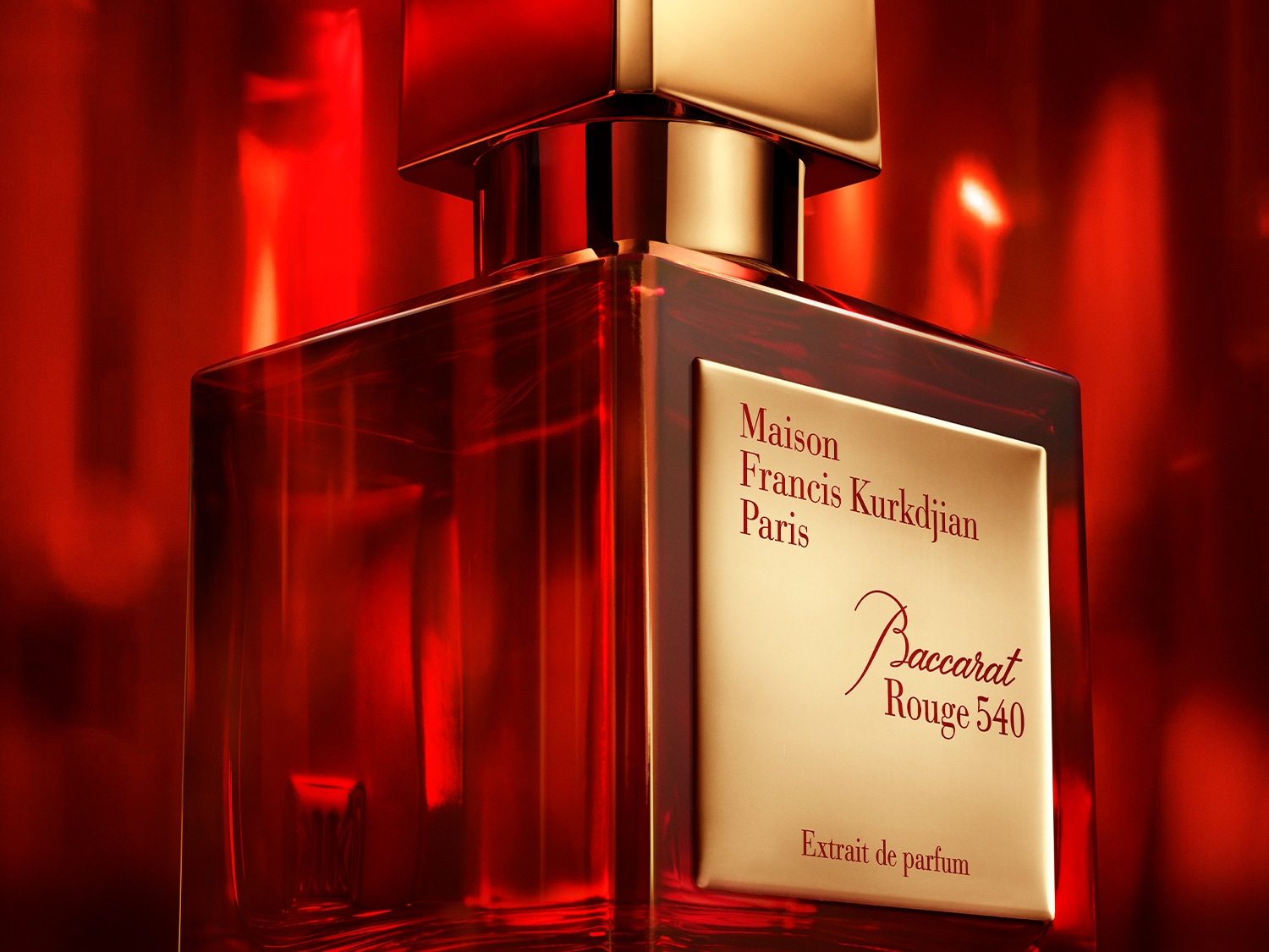 Nahaufnahme des Baccarat Rouge 540 Extrait de Parfum Flakons von Maison Francis Kurkdjian Paris, mit goldenem Etikett auf einem roten Glasflakon.