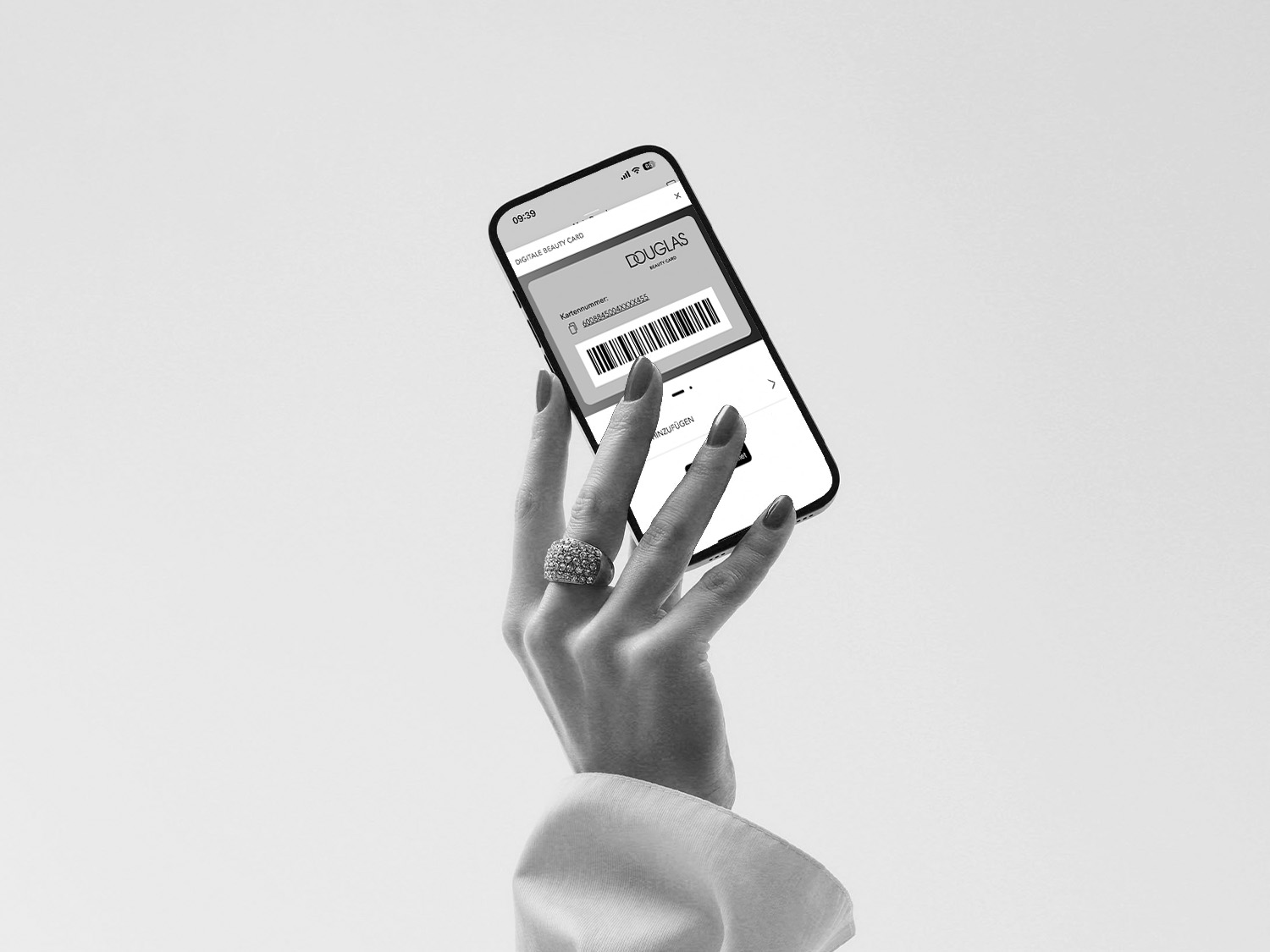 Elegancka dłoń trzyma telefon z aplikacją Douglas Beauty Card, prezentując cyfrową kartę lojalnościową.